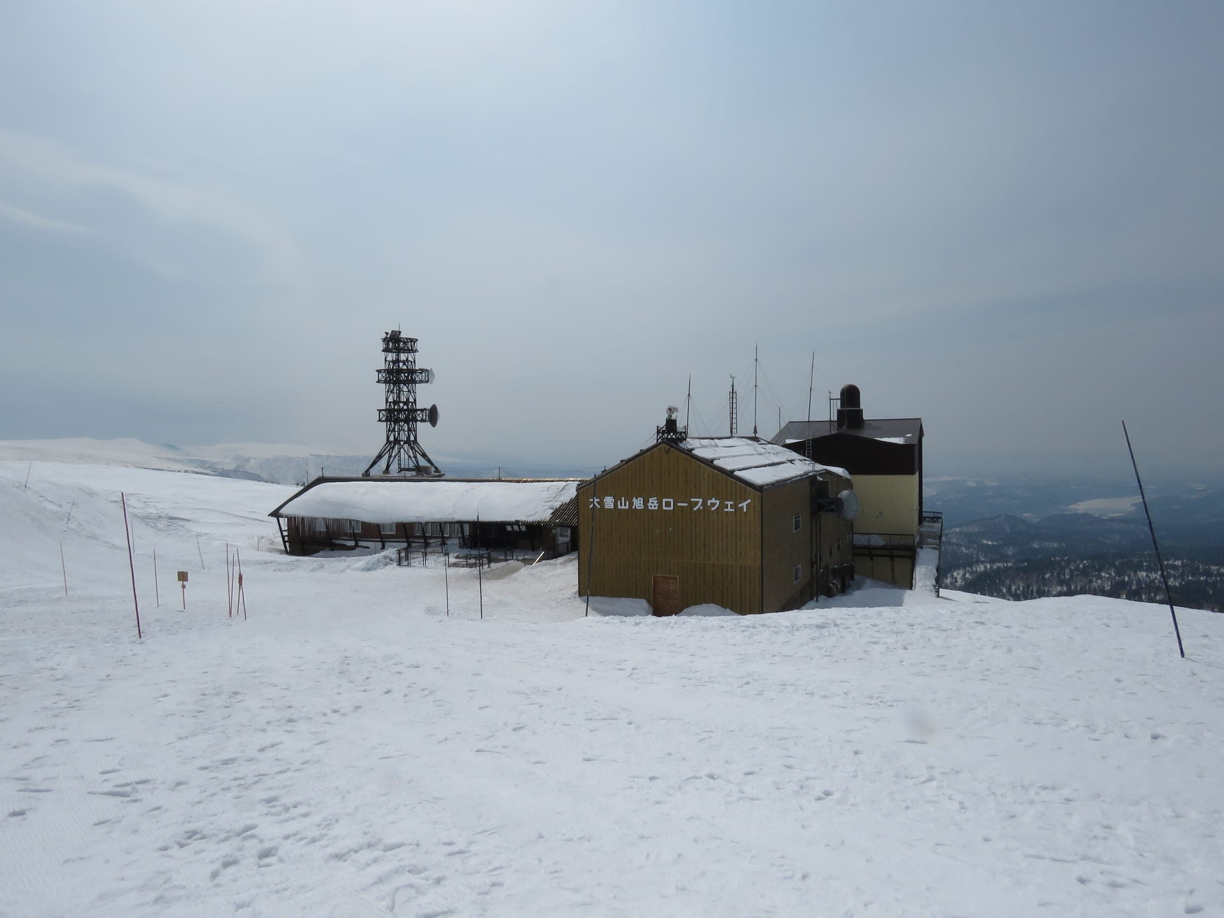 The Asahidake Ropeway upper station stands on an open snowfield above the valley