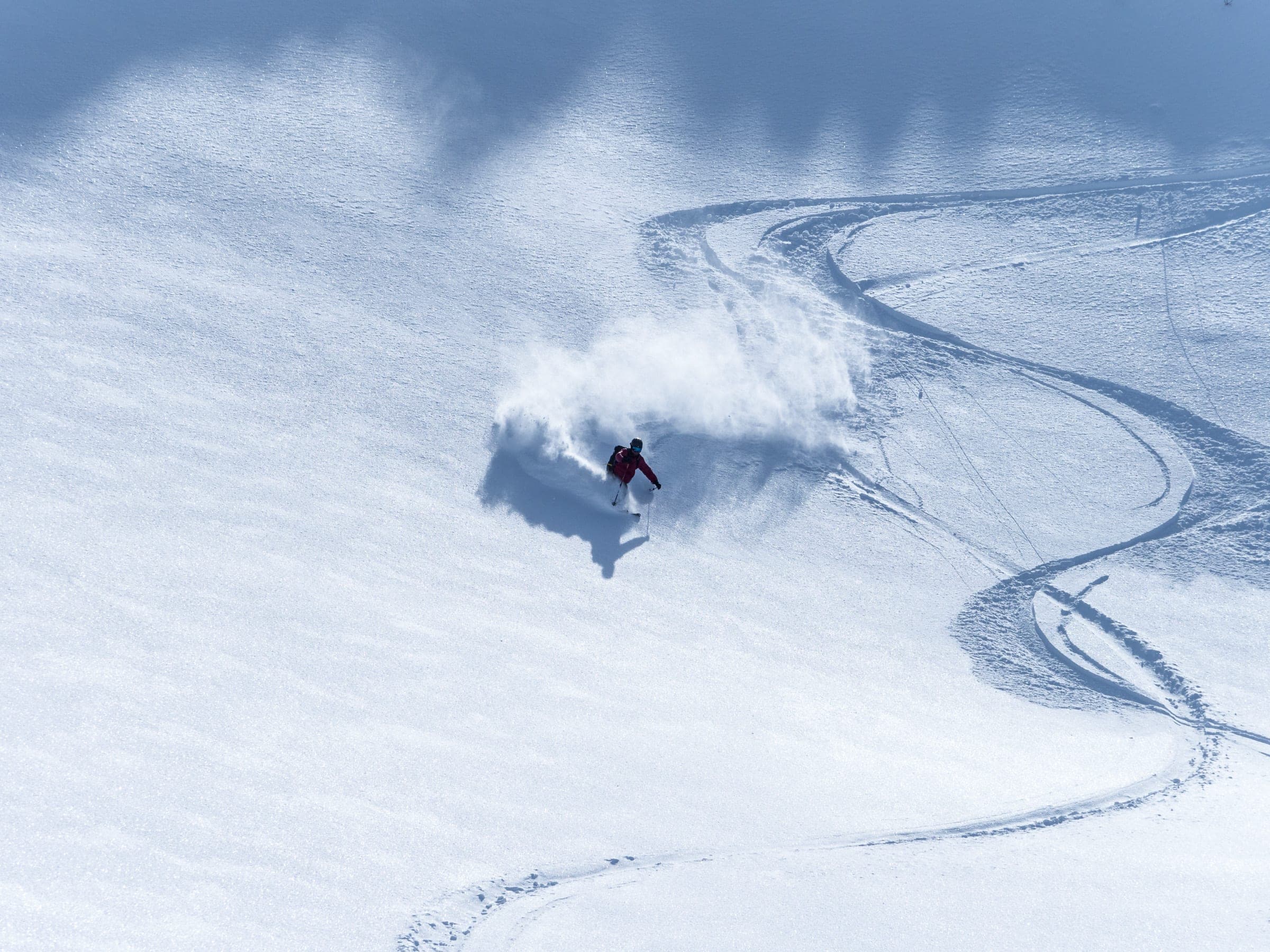 A skier carves fresh turns down the open Kaun Bowl below Furano-dake