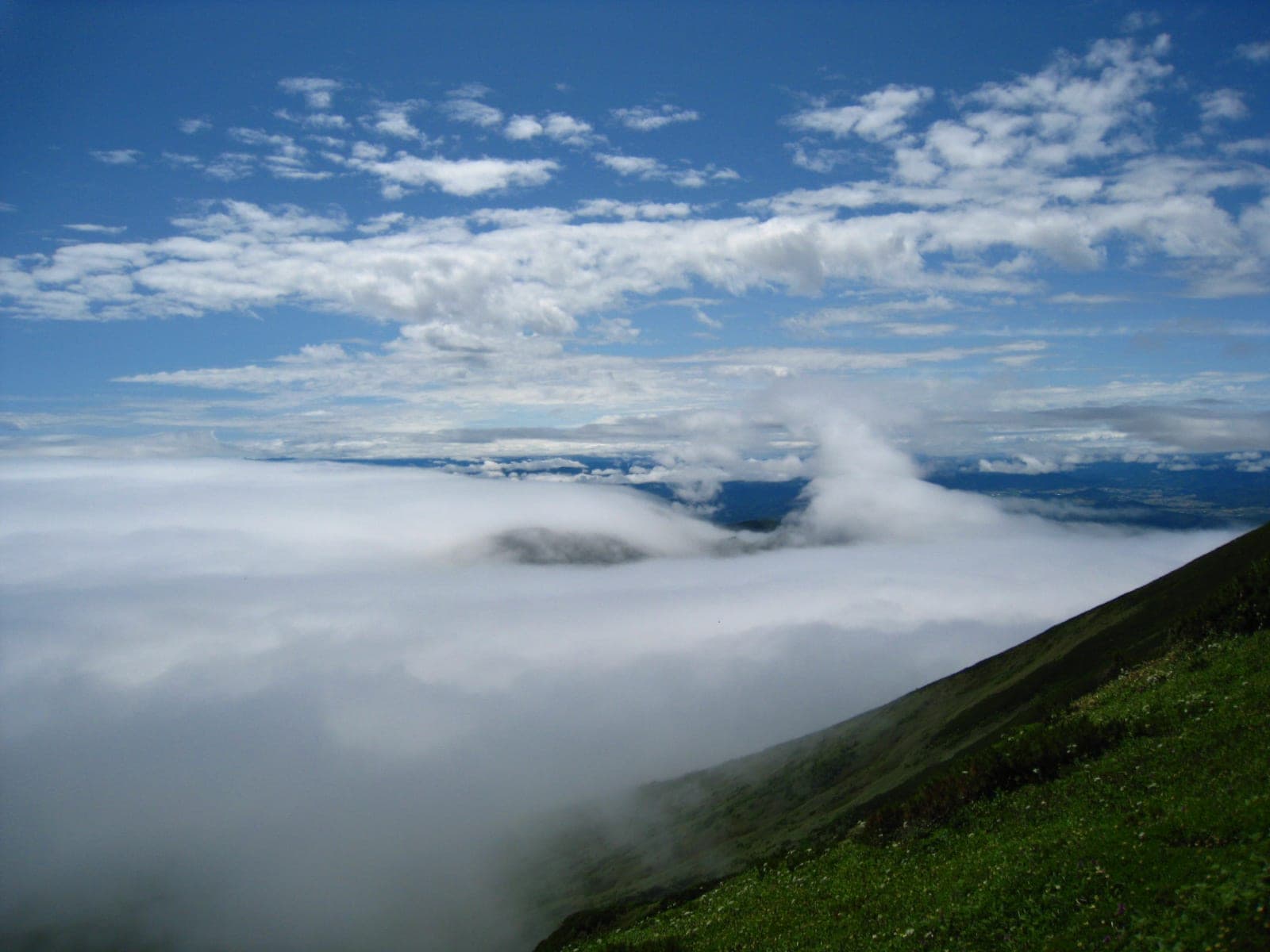 A sea of cloud spills over the ridges seen from the slopes of Furano-dake