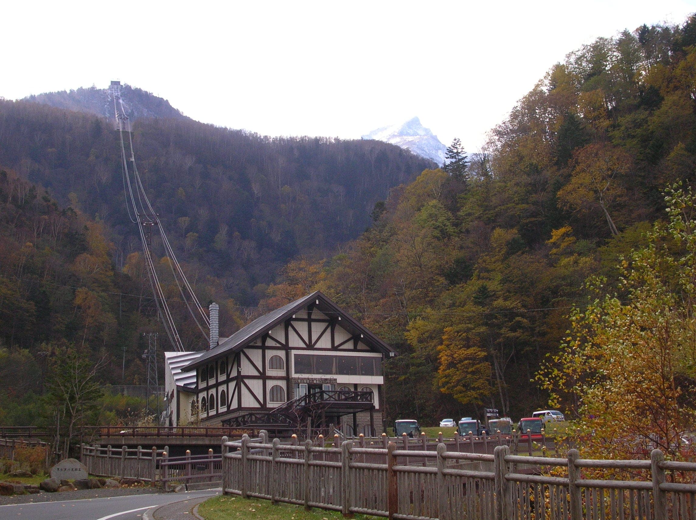 The Kurodake Ropeway climbs from its Sounkyo station through autumn forest toward a snow-dusted peak