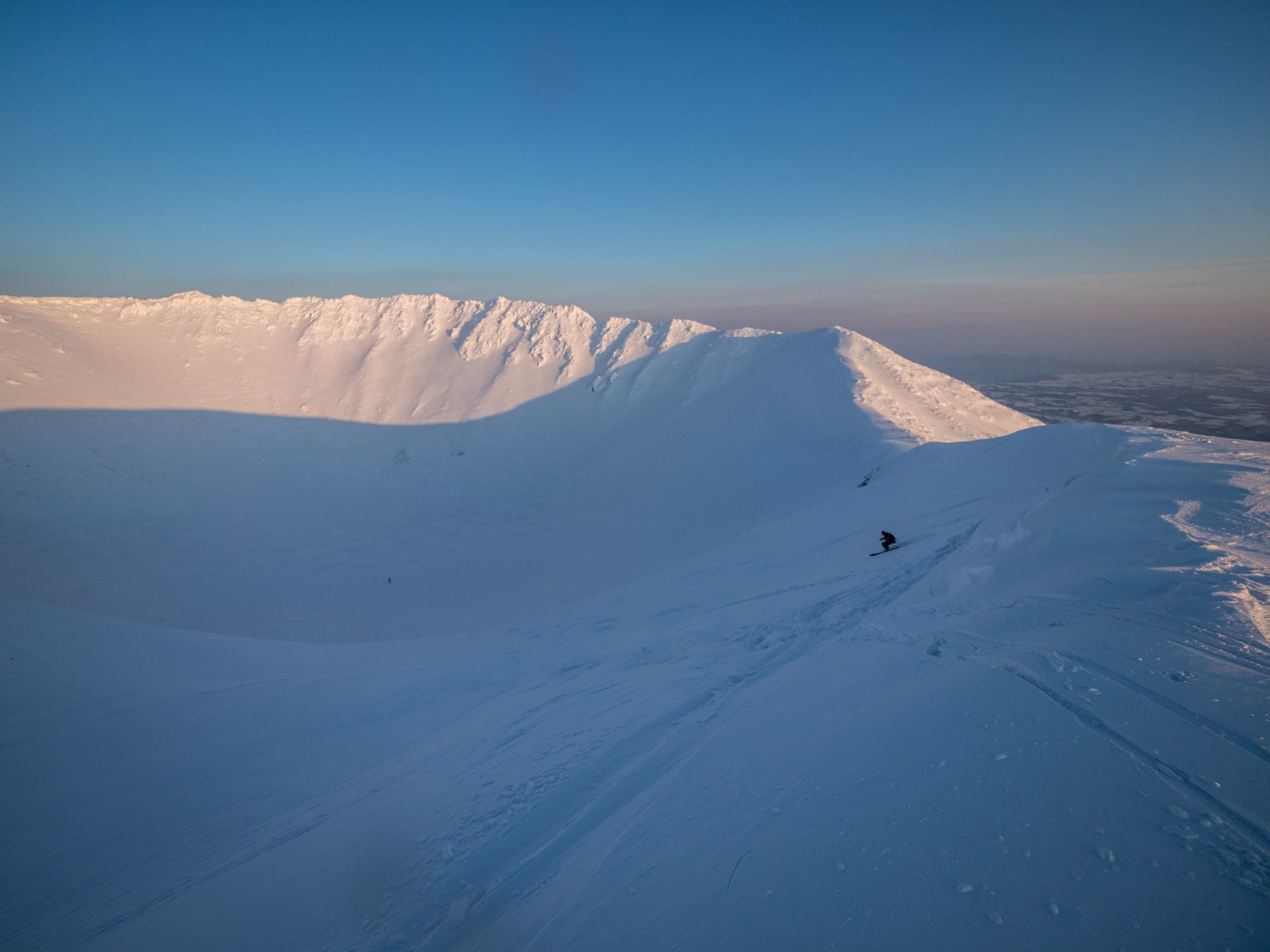 Evening light falls on the snow-filled summit crater rim of Mt. Yotei