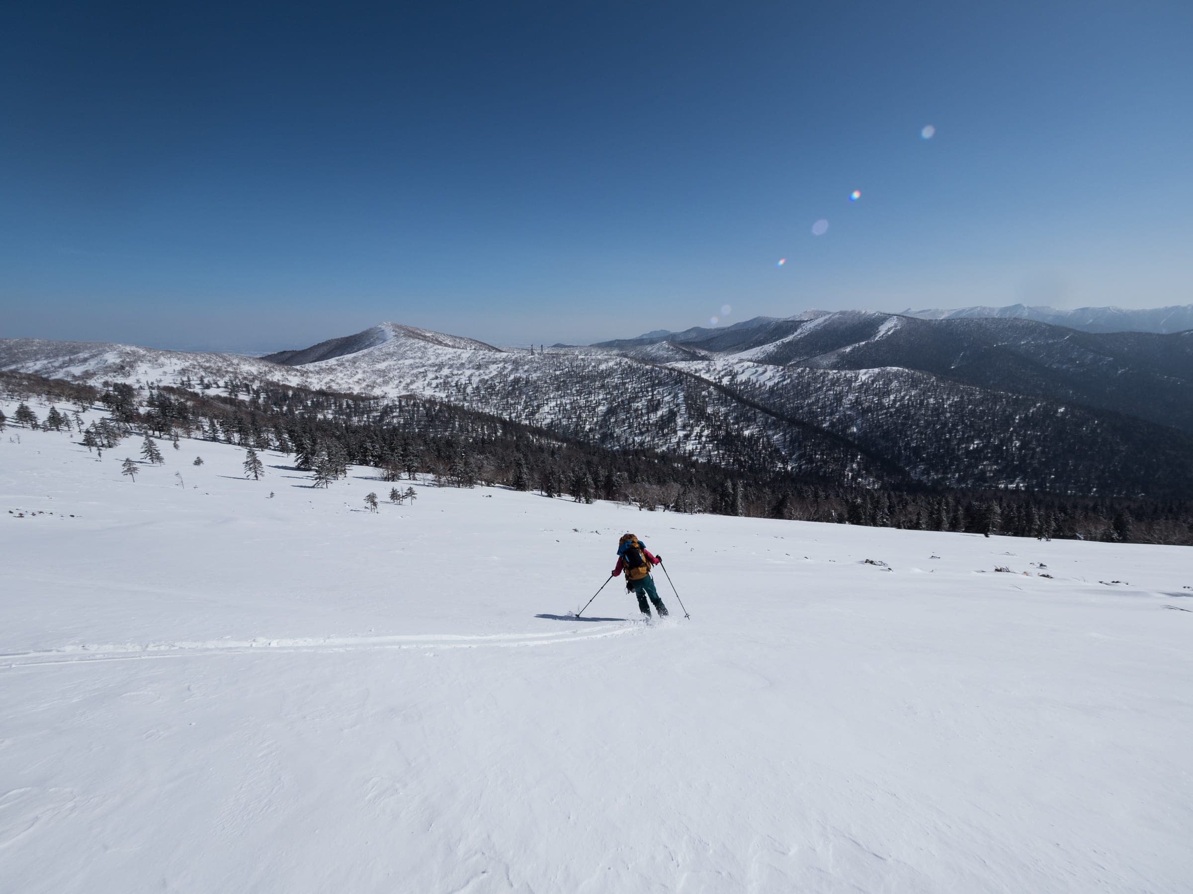 A skier descends the open south slopes of Soshubetsu-dake near Nissho Pass