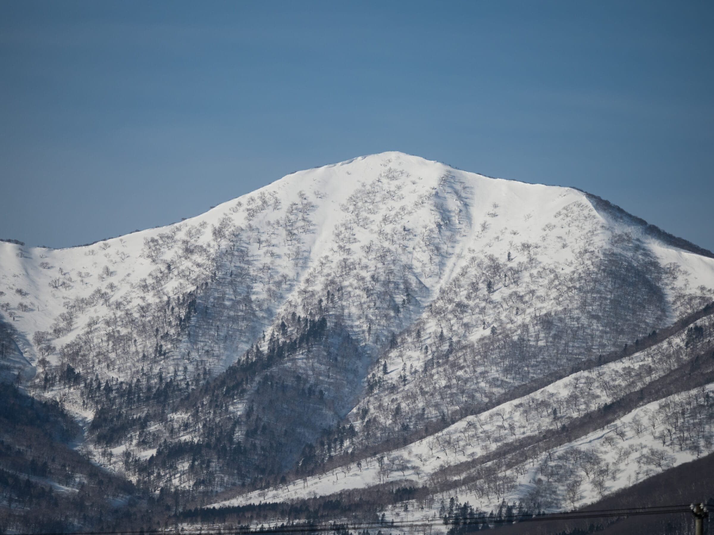 The steep east face and ridges of Pekerebetsu-dake rise above Nissho Pass