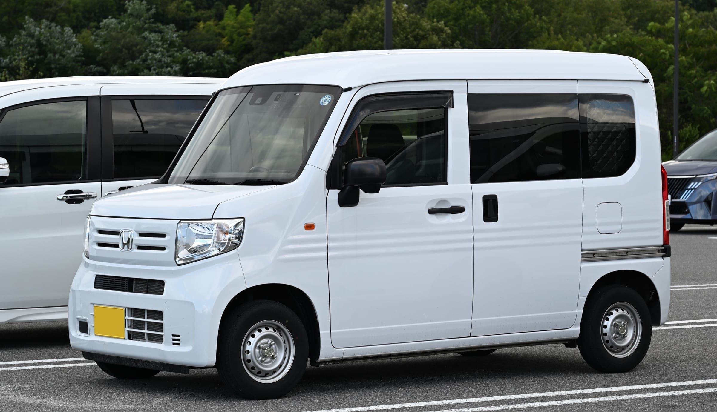 A white Honda N-VAN, the kei van that QUUM rents as its smallest camper