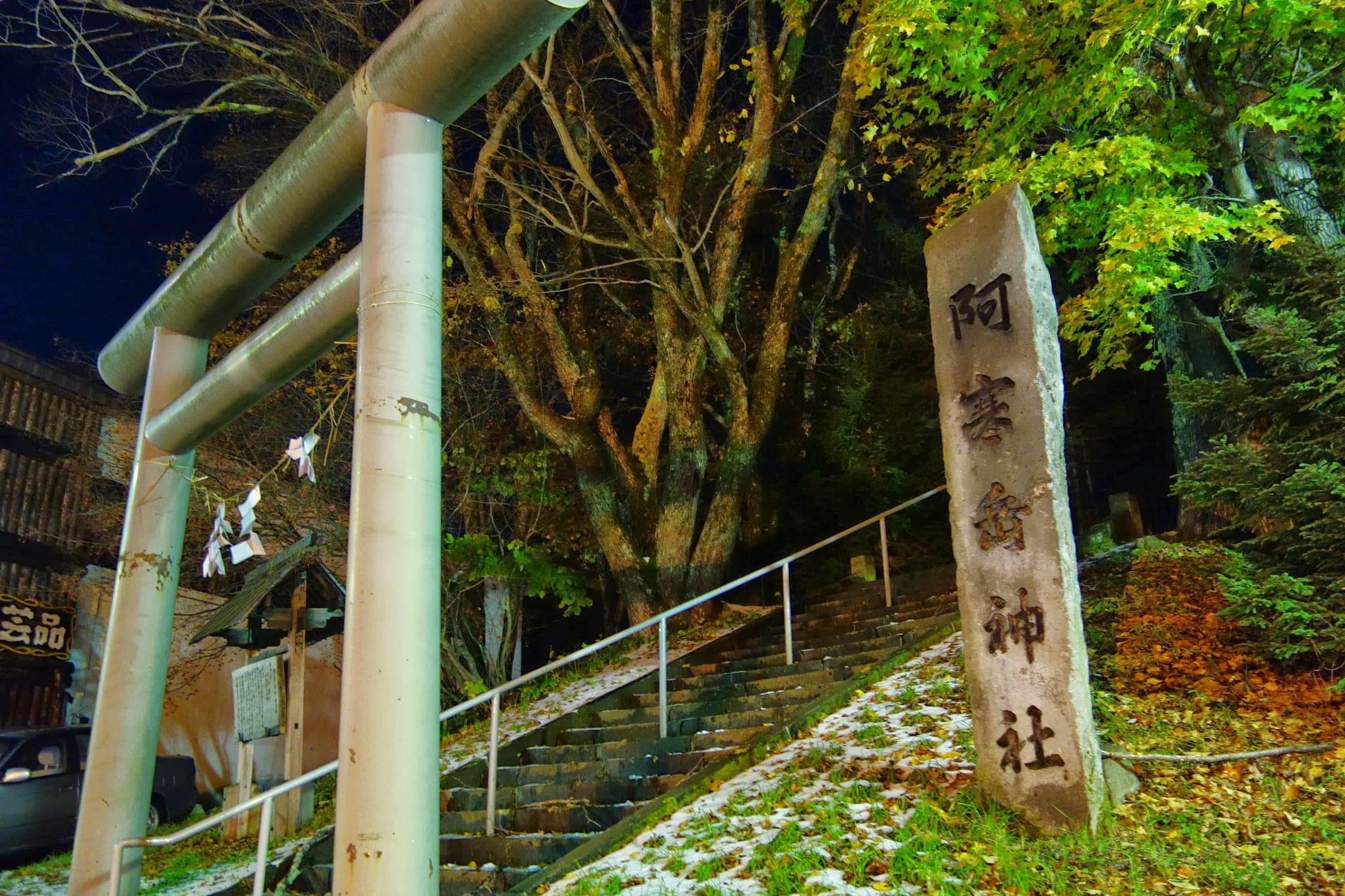 A wooden torii and stone steps lead up to Akan Shrine in Akanko Onsen at night