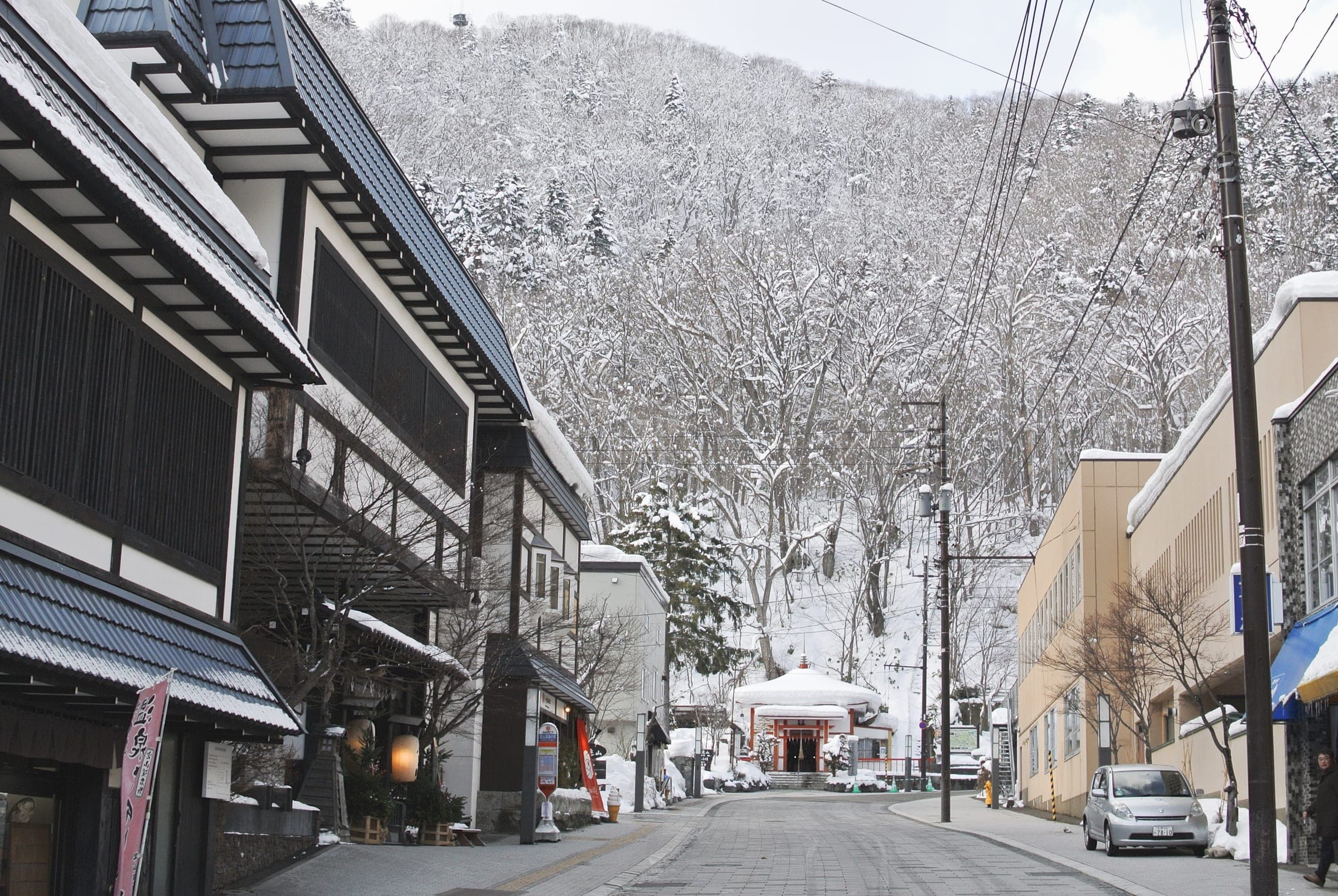 Snow lines a quiet street of inns and shops in Jozankei Onsen in January