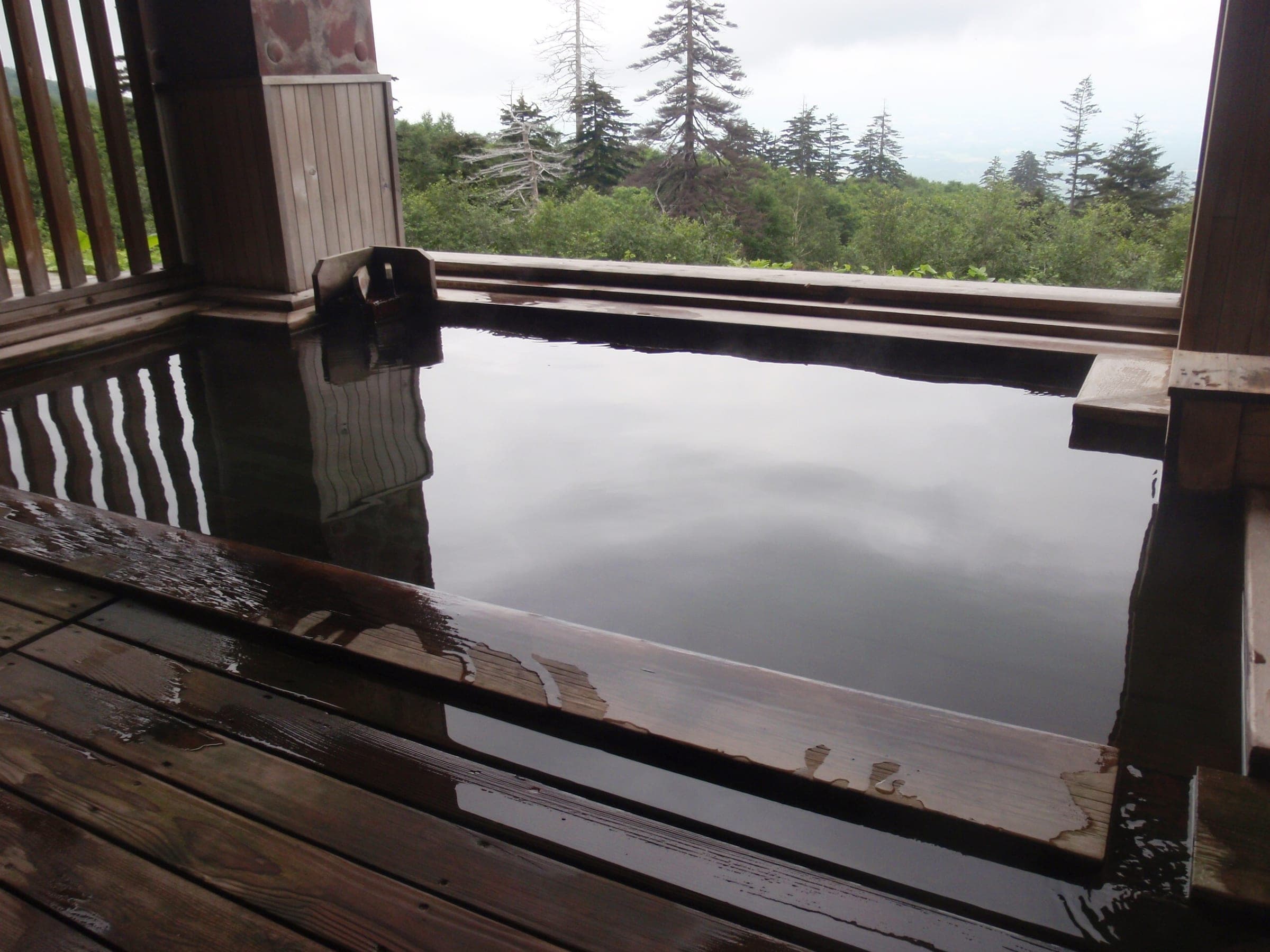 The wooden rotenburo at Kamihoroso looks out over forest and the Furano basin below