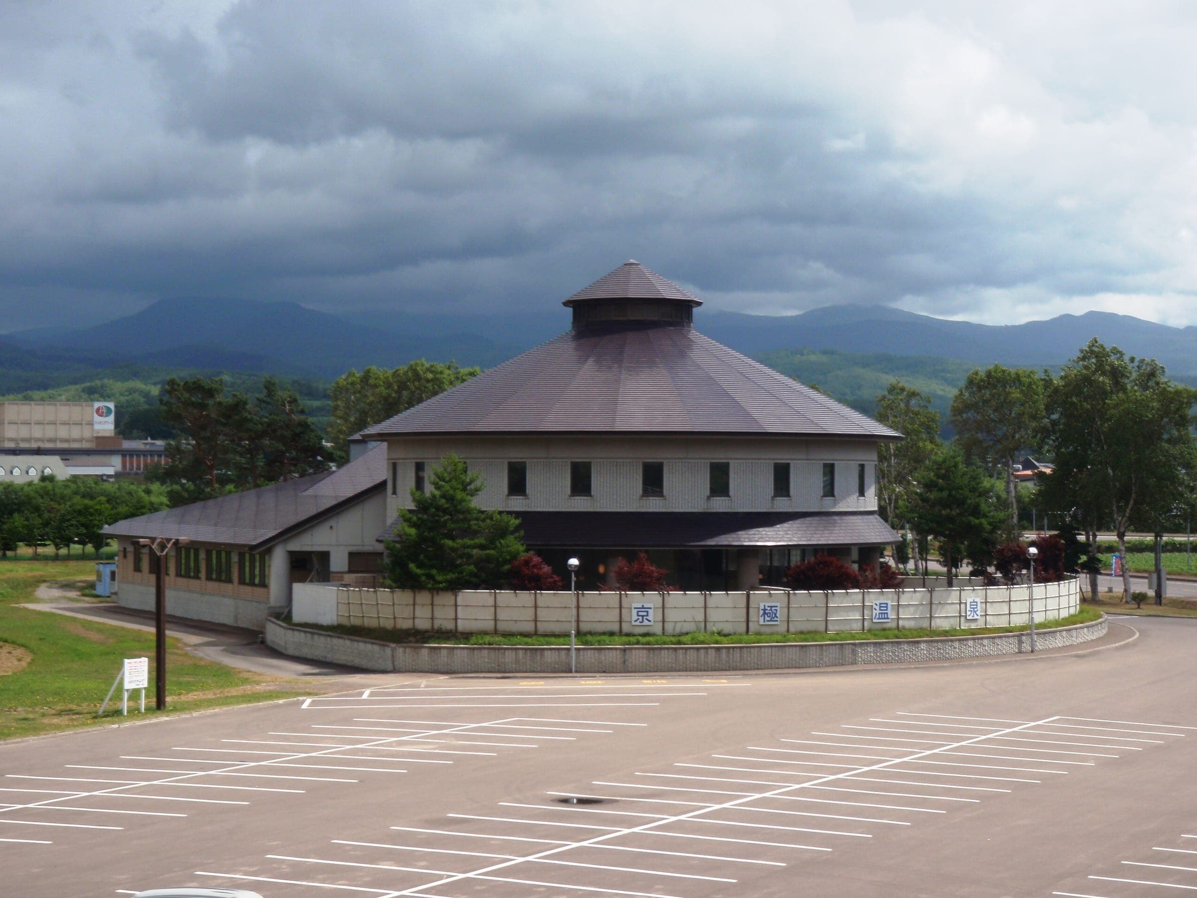 The round, hip-roofed Kyogoku Onsen building under a heavy sky