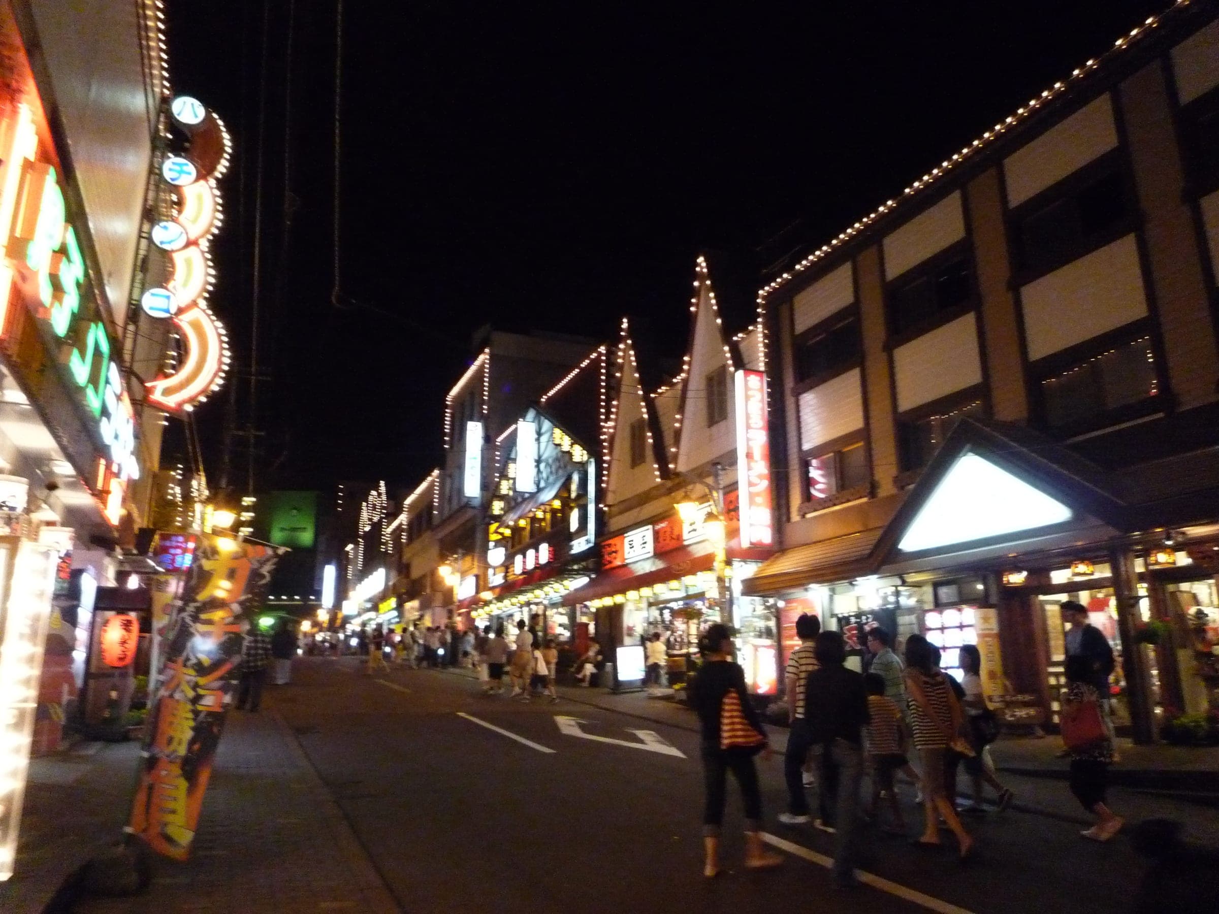 Noboribetsu Onsen's main street at night, lined with lit shopfronts near the Sagiriyu bathhouse