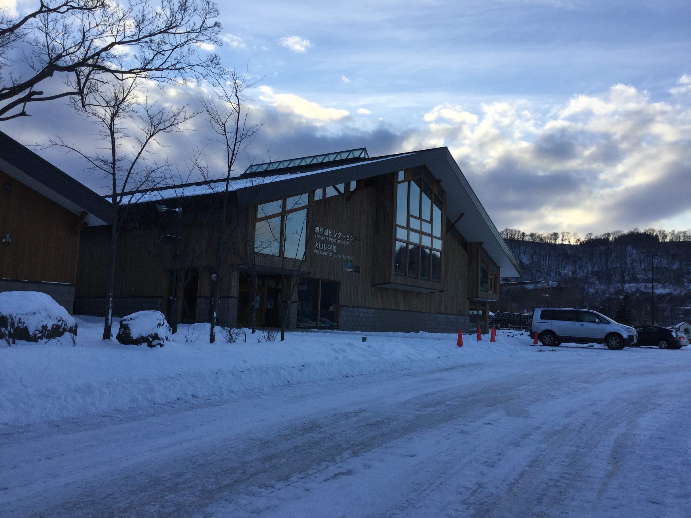 A timber hall with tall gable windows stands in fresh snow at Toyako Onsen