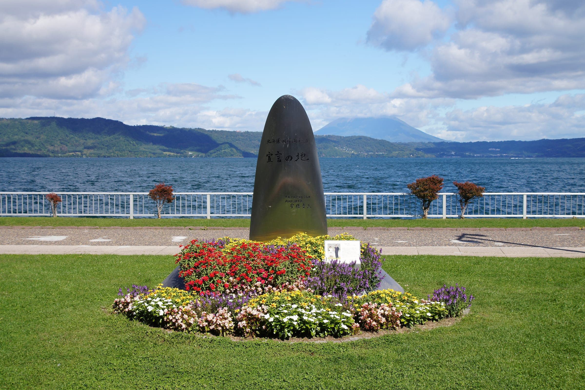 A stone monument and flower bed on the shore of Lake Toya at Toyako Onsen