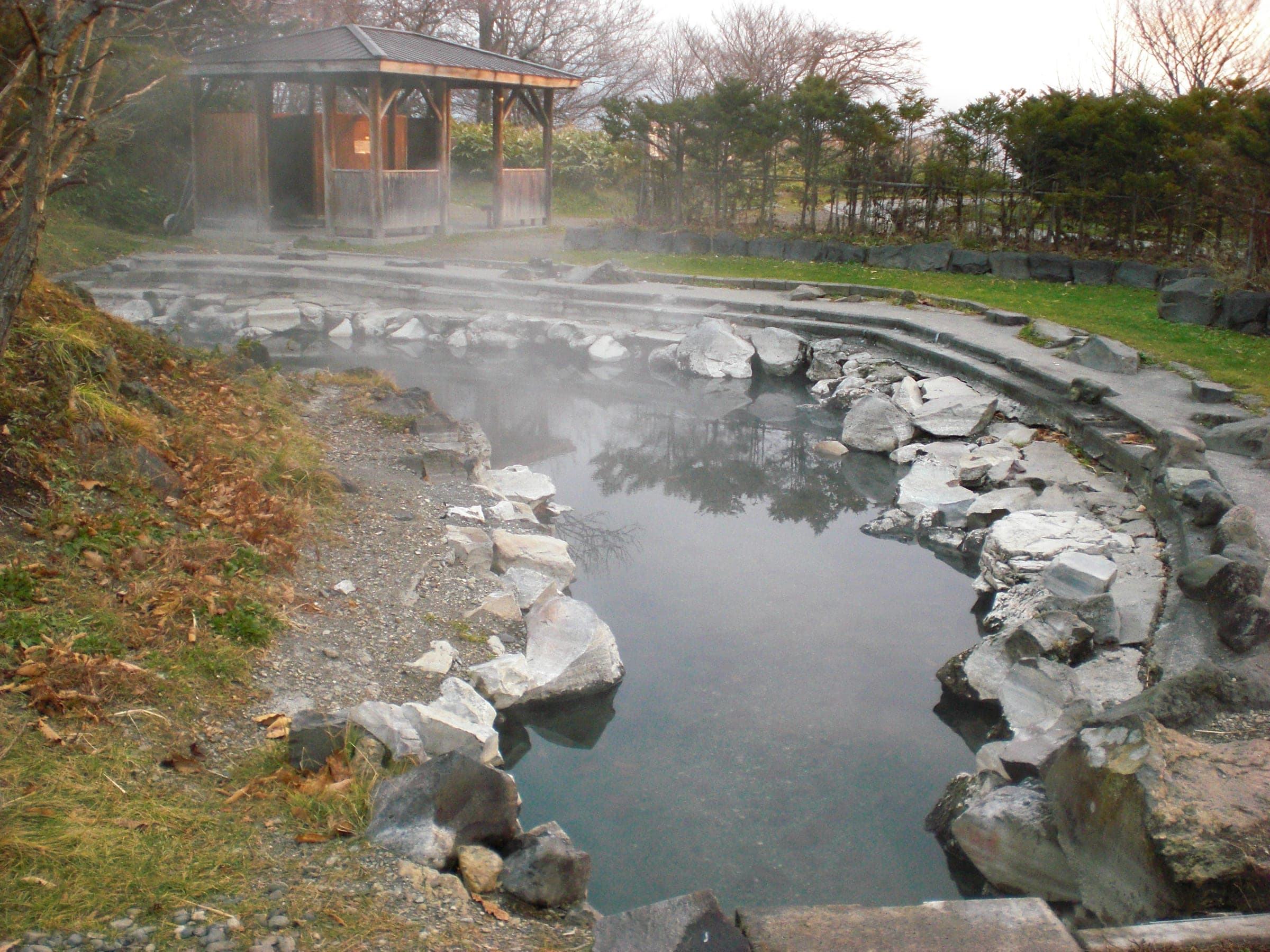 Steam rises off the rock-lined open-air bath at Wakoto Onsen on Lake Kussharo