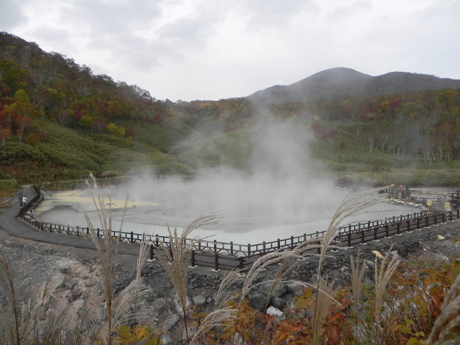 Steam rolls off the fenced Oyunuma pond beside Yukichichibu in autumn