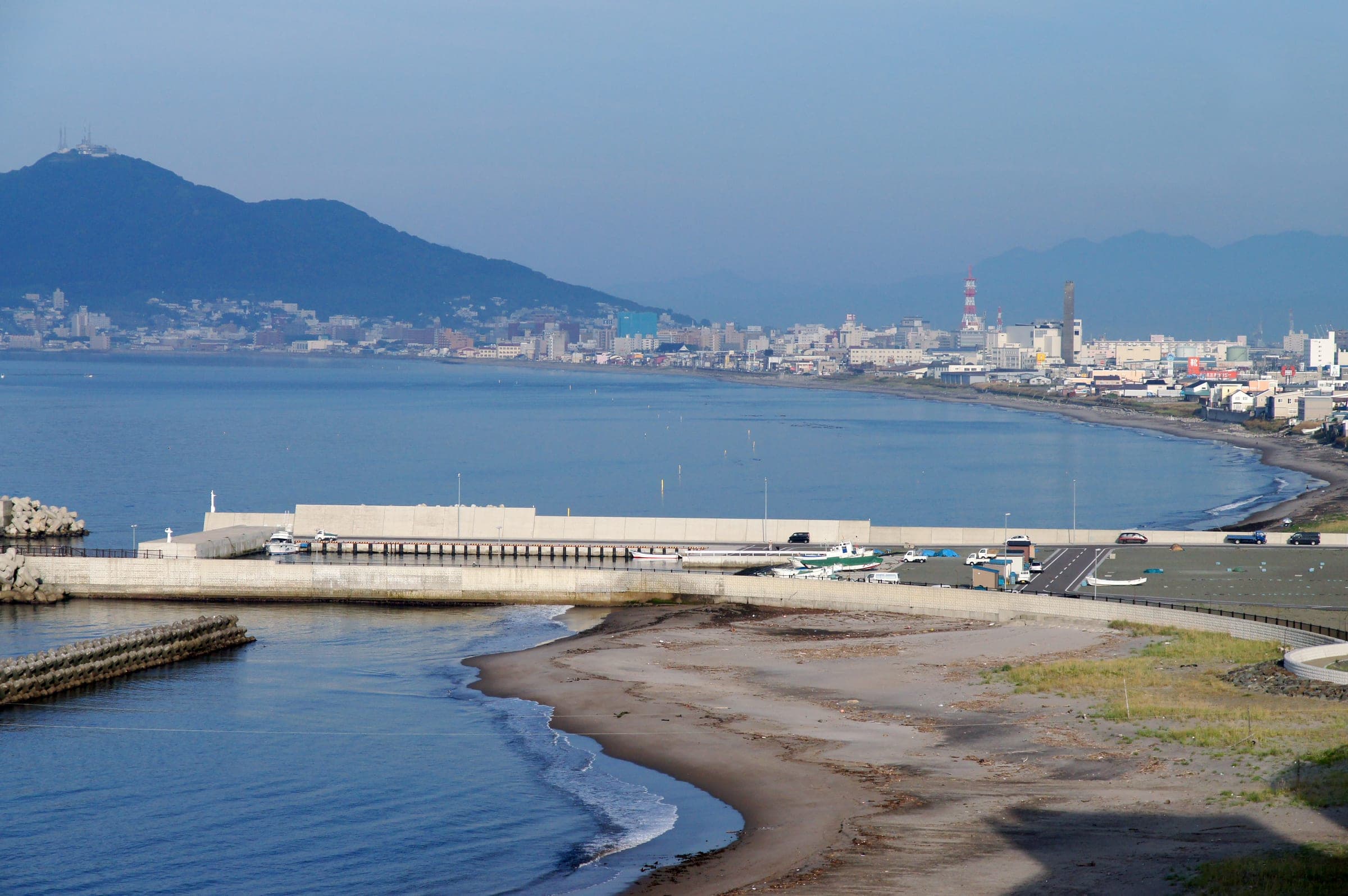 The Yunokawa Onsen shoreline curves toward Mt. Hakodate across the bay