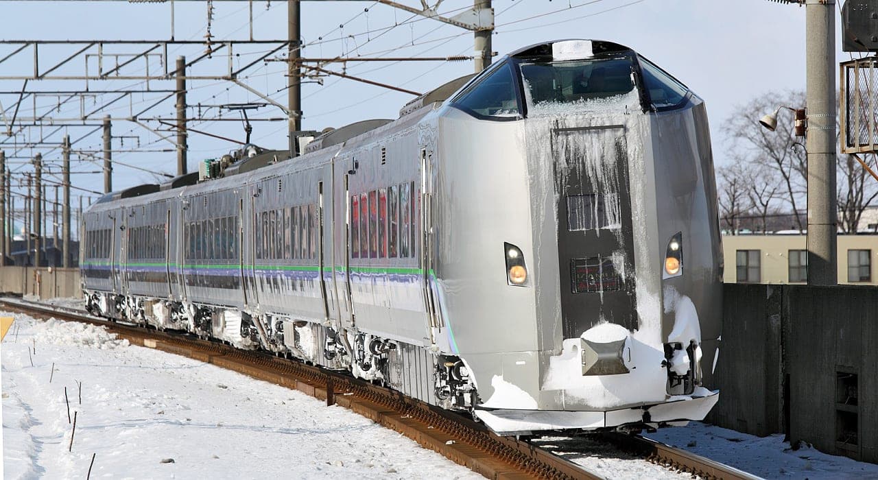 A JR Hokkaido 789 series train on an Airport service approaches Chitose Station in snow