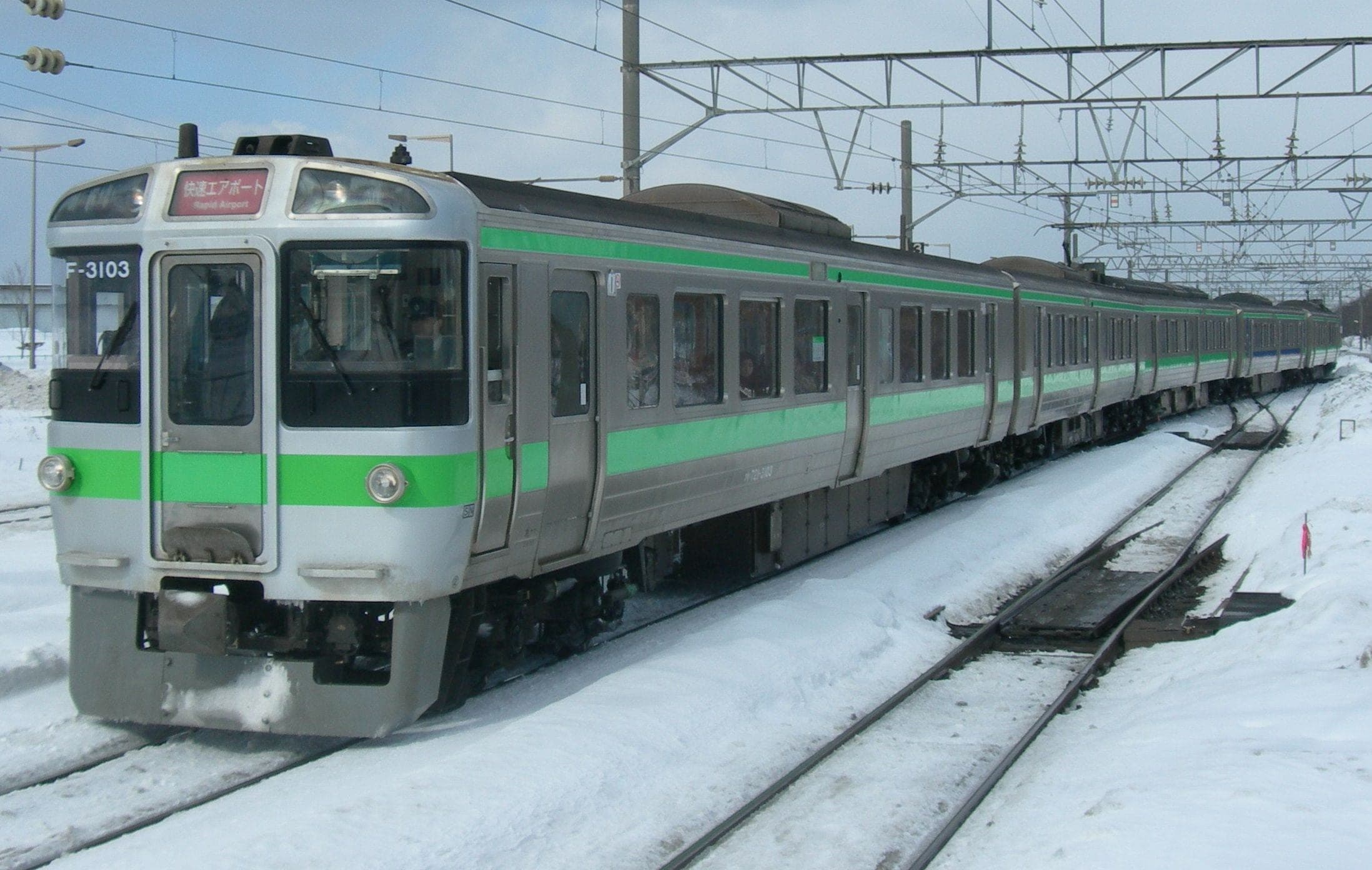 A JR Hokkaido 721 series Rapid Airport train runs through snow