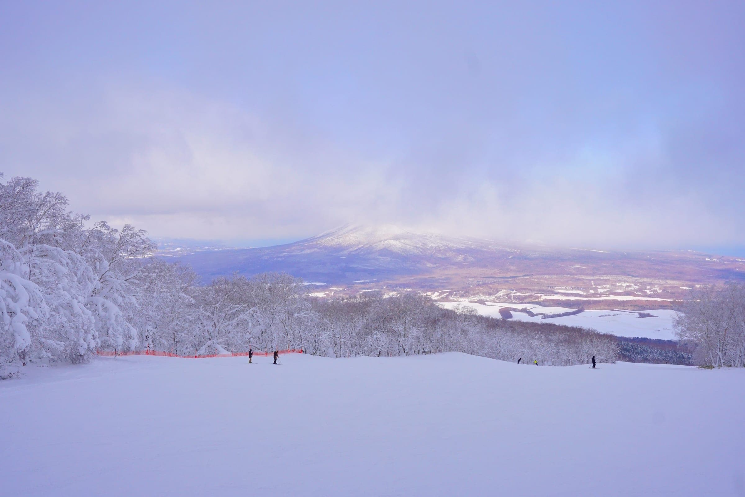 Komagatake rises beyond Lake Onuma with its summit in cloud, seen from the top of Hakodate Nanae Snowpark