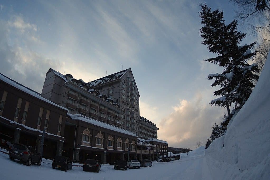 The Kiroro hotel rises above deep snowbanks under a dusky winter sky
