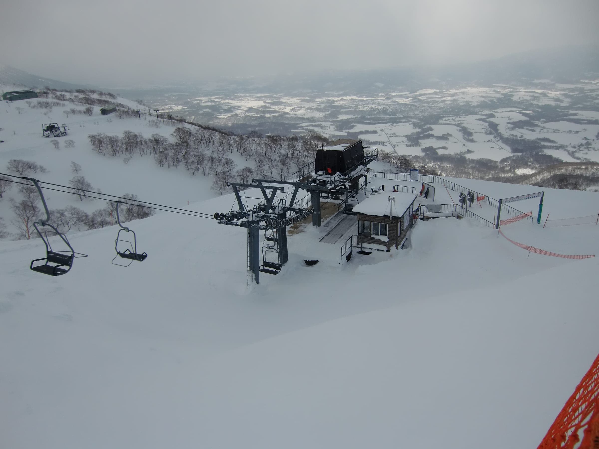 The Jumbo 4th pair lift at Niseko Annupuri looks out over snowy farmland below