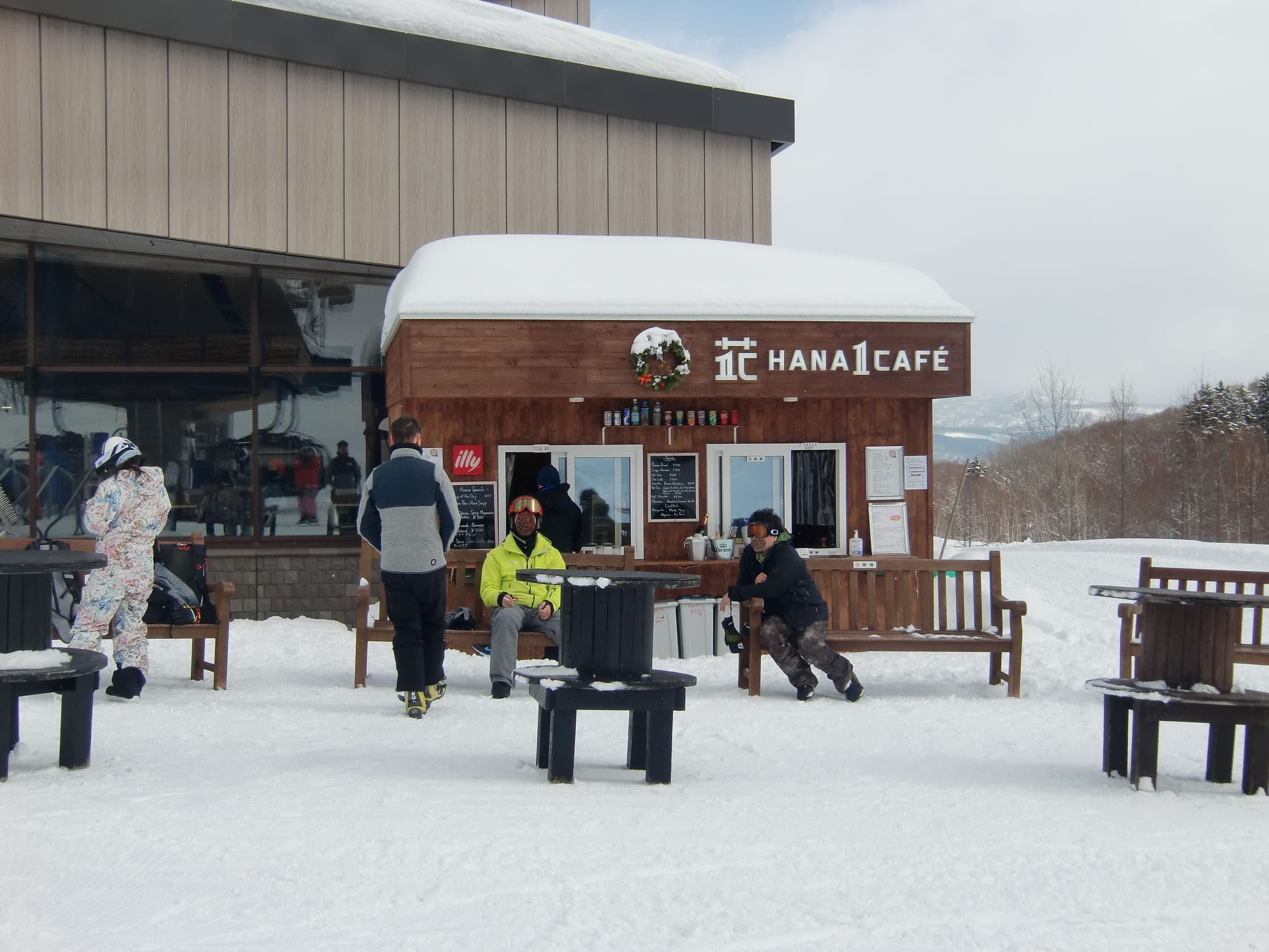 Skiers rest at tables outside HANA 1 Cafe at the foot of the HANAZONO slopes