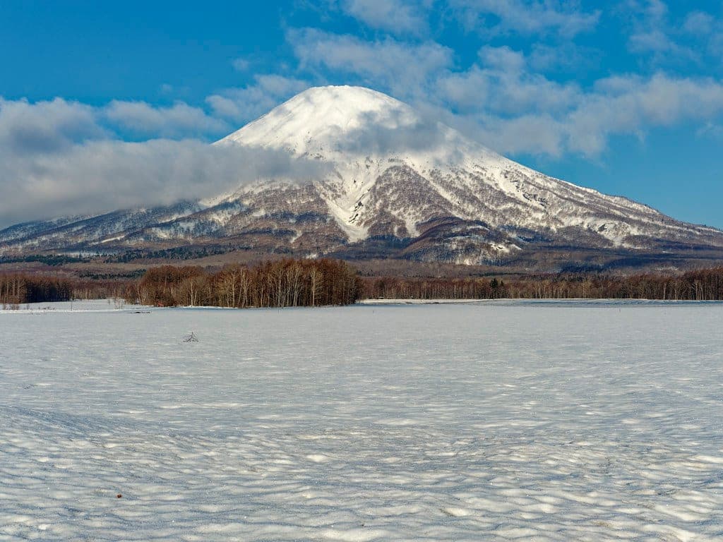 Mt. Yotei rises white above snowfields near Rusutsu under a clear blue sky