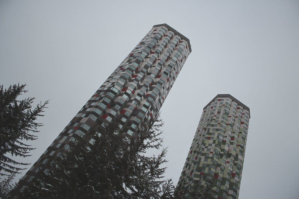 The twin towers of Hoshino Resorts Tomamu rise into winter fog above the trees