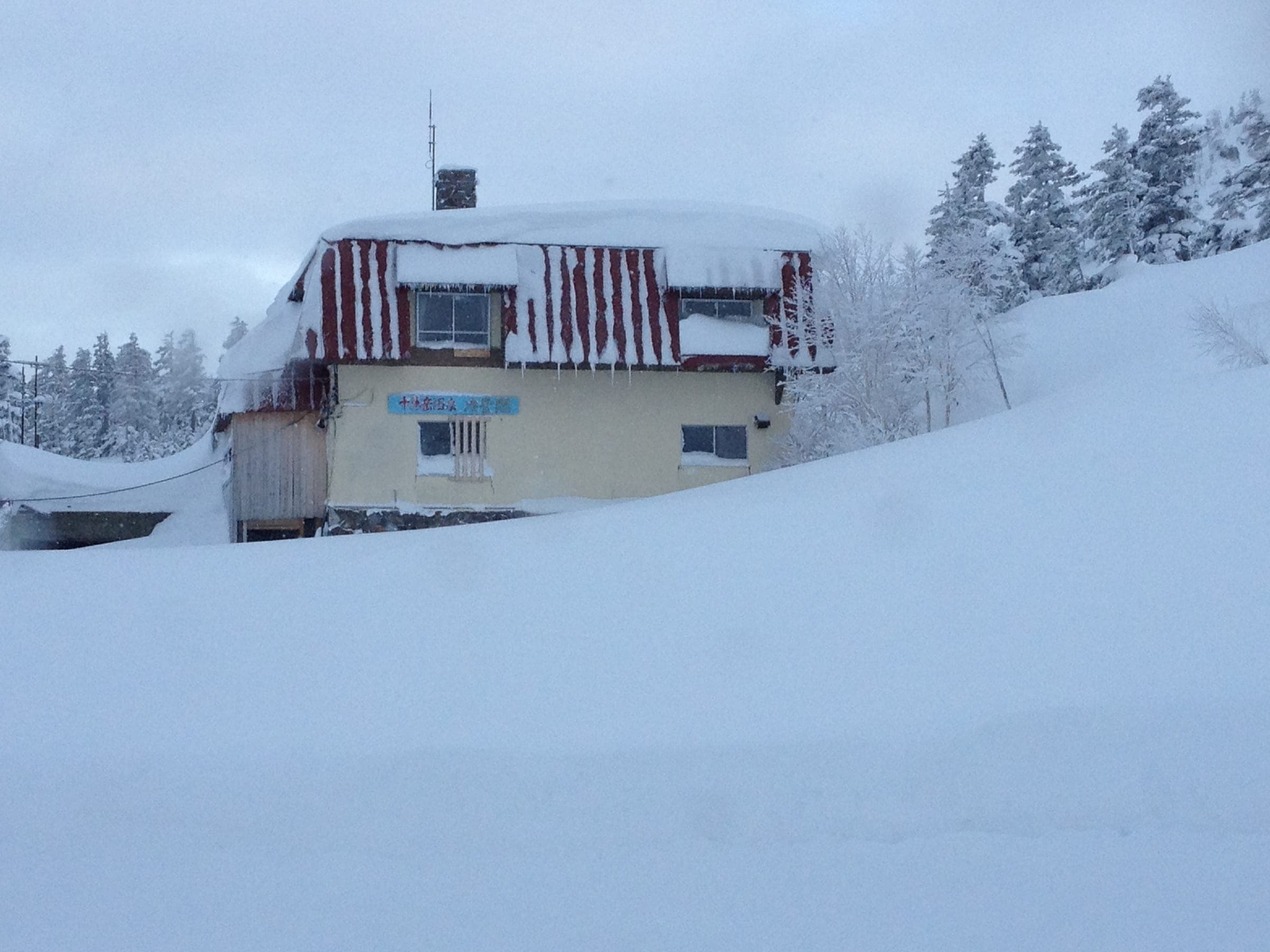 Ryounkaku's inn building half buried in winter snow at Tokachidake Onsen