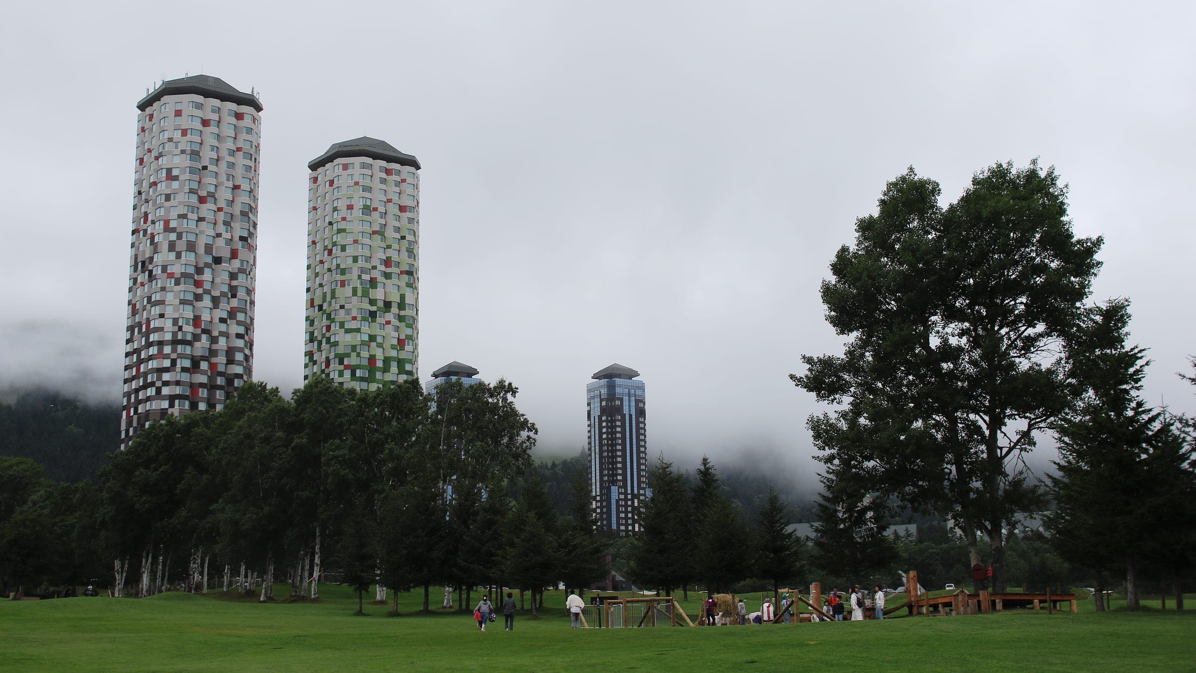 The Tower's twin towers rising over forest into low cloud at Tomamu