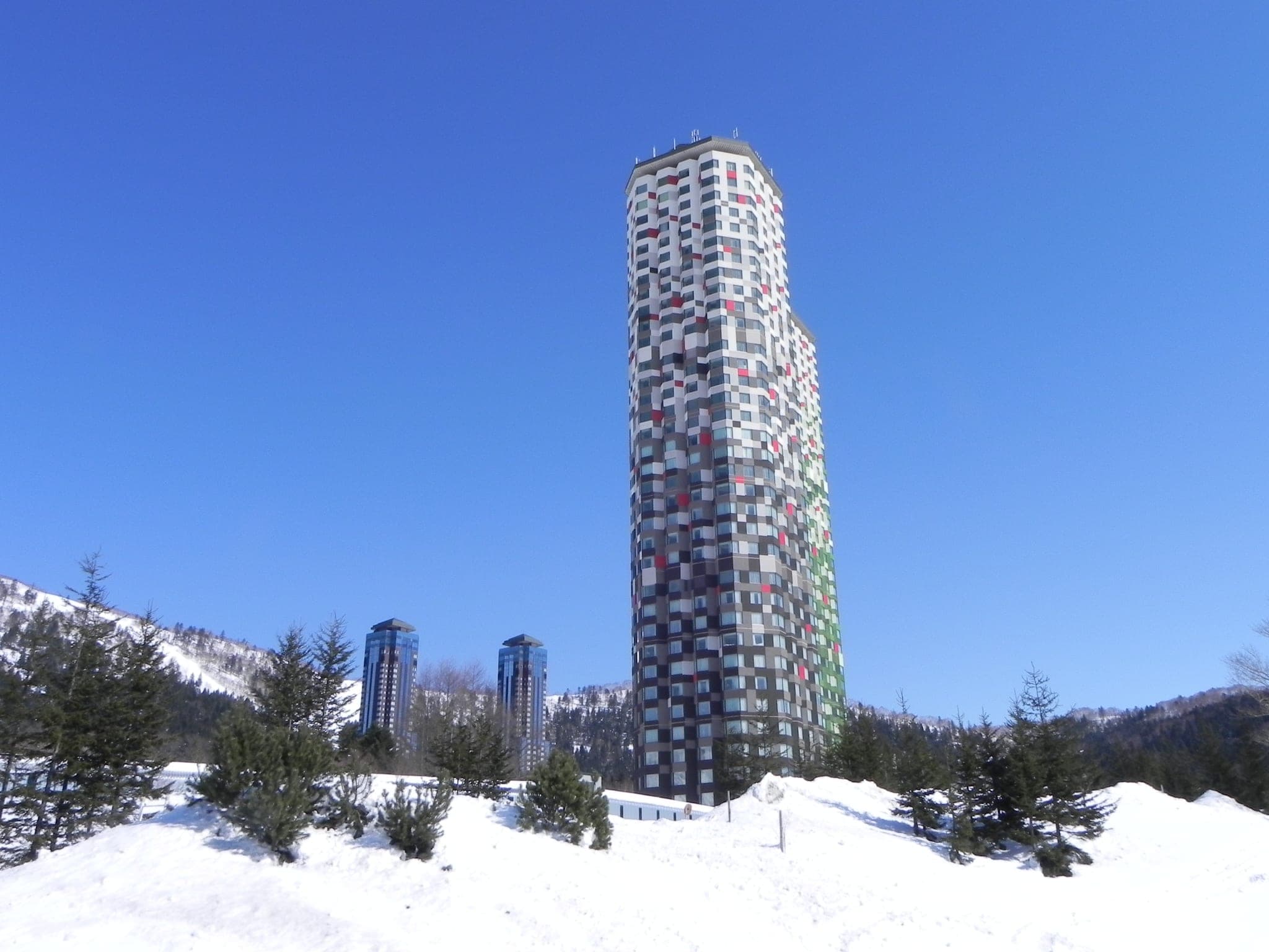 Snowy conifers surround a hotel tower at Tomamu, the forest resort that holds the Kirin-no-Yu bath