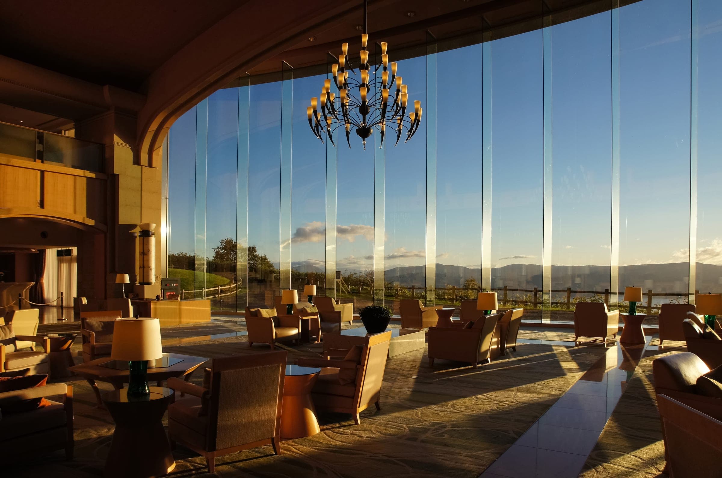 A lounge at The Windsor Hotel Toya with floor to ceiling windows and a chandelier