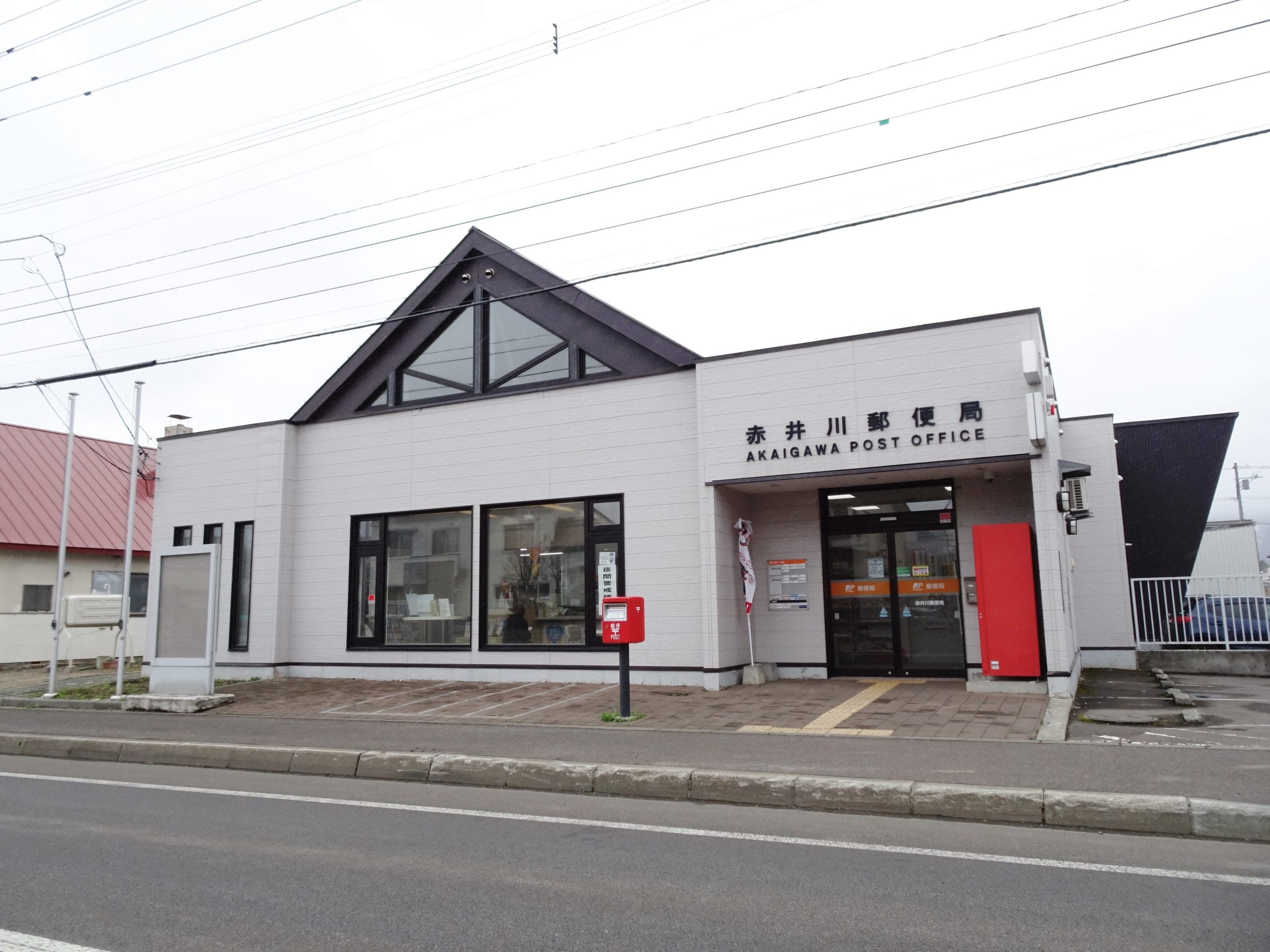 Akaigawa post office has white walls and a peaked glass gable