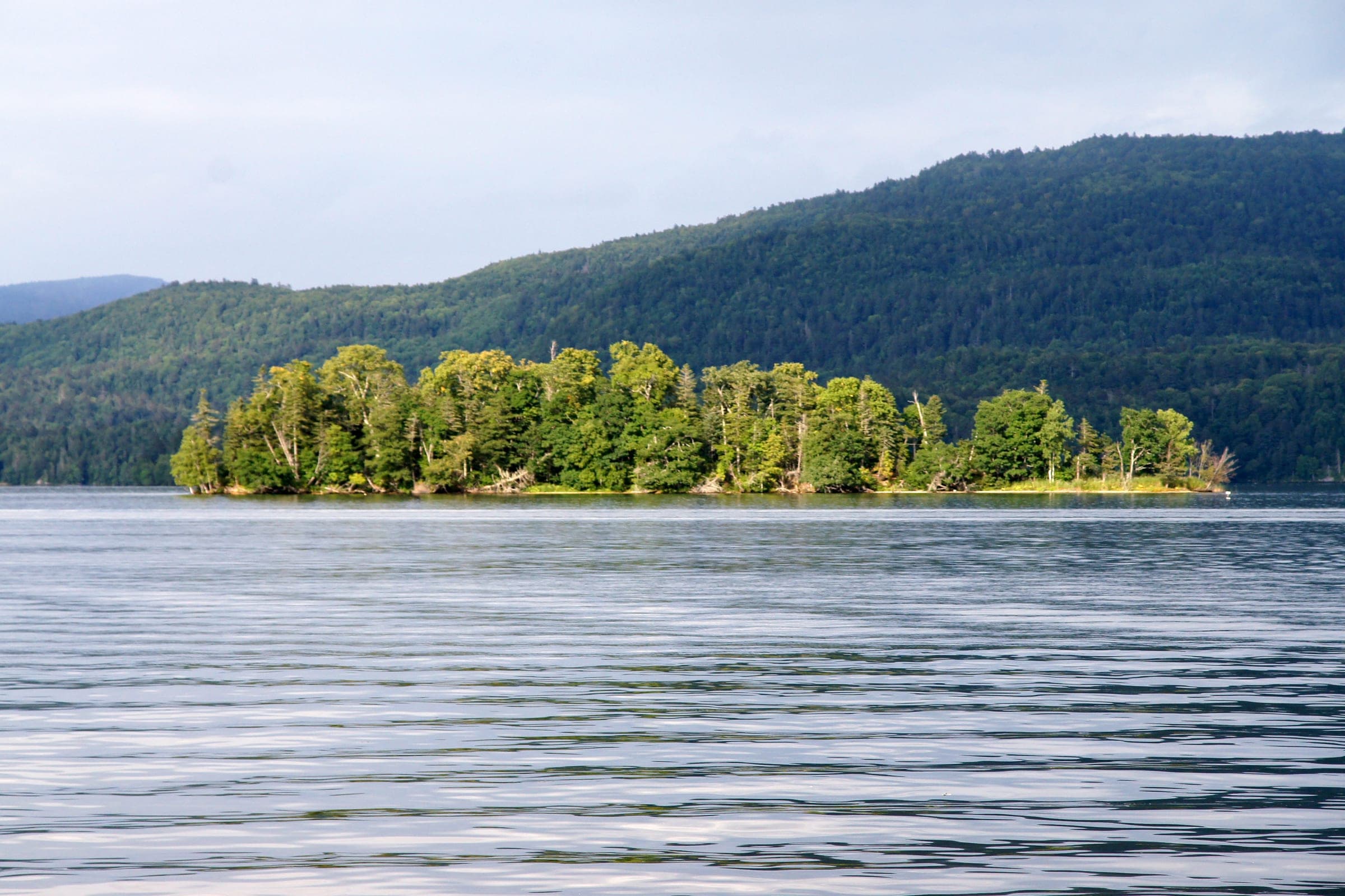 A small wooded island sits on the still water of Lake Akan