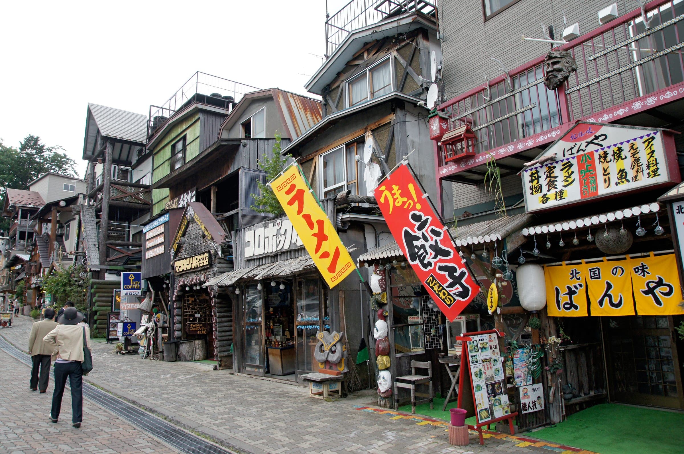 Craft shops and banners crowd the lane through the Ainu Kotan in Akan