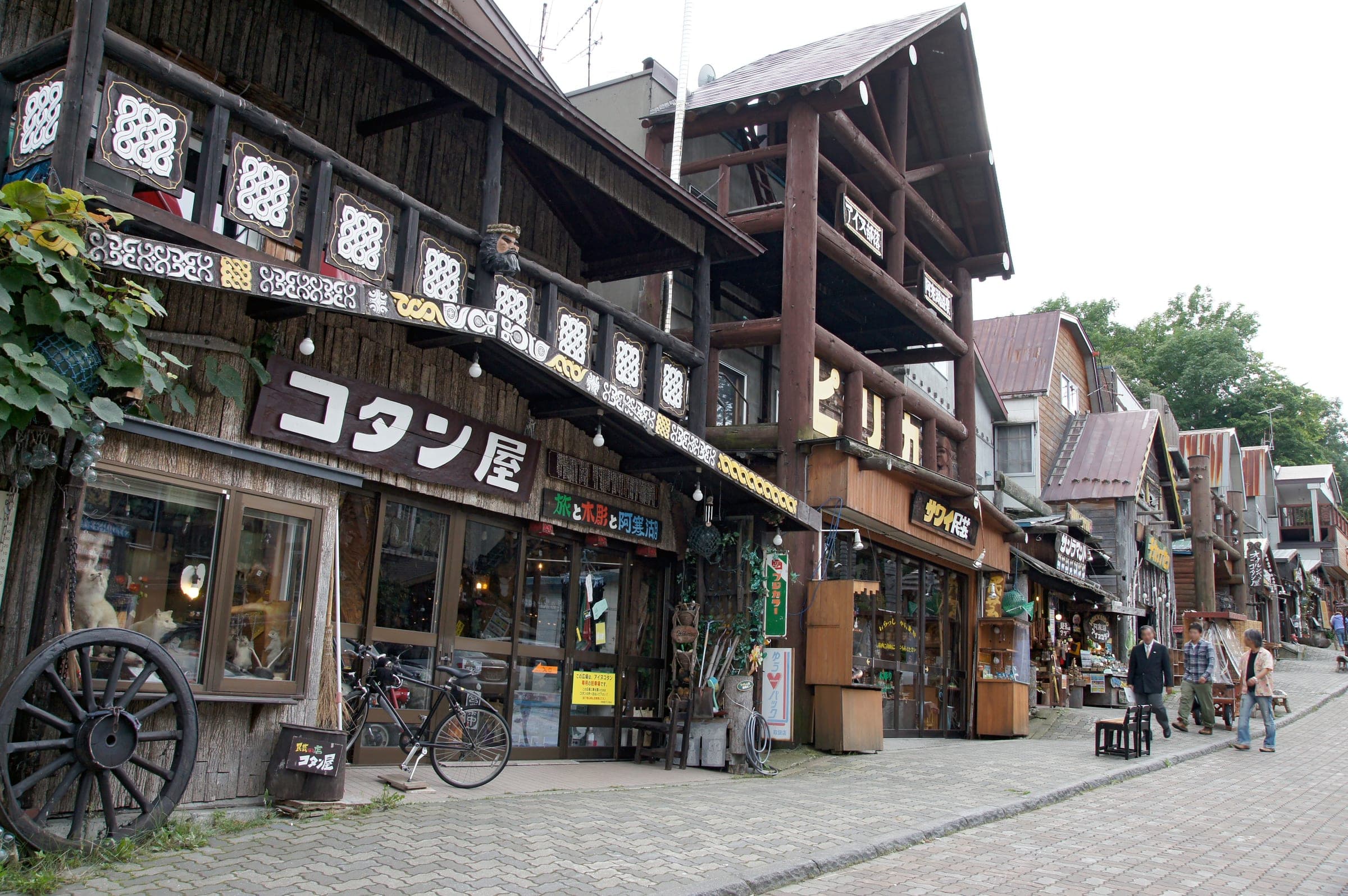 Carved wooden shopfronts line the main street of the Ainu Kotan in Akan