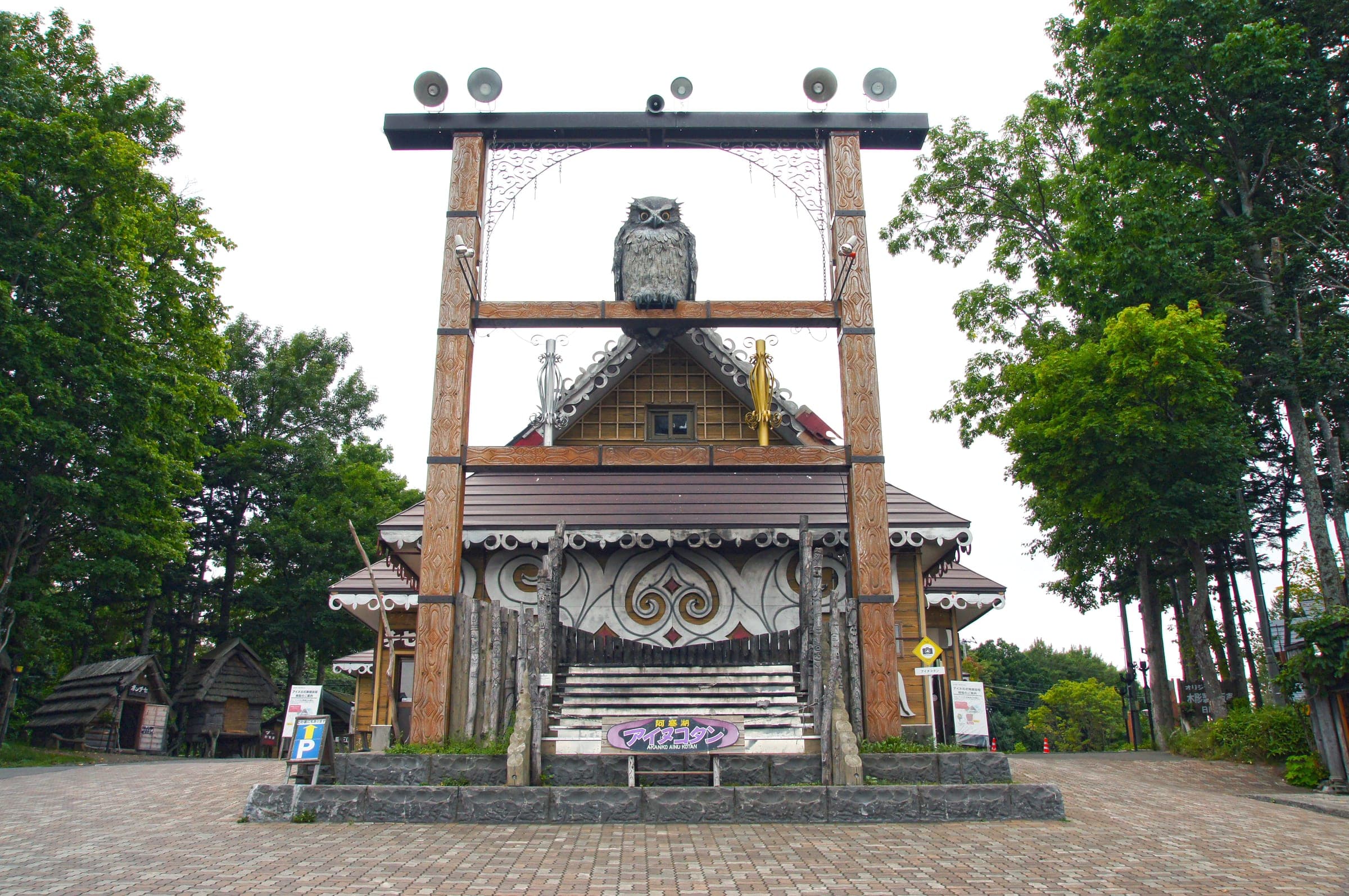 A carved owl tops the wooden gate at the Ainu Kotan in Akanko Onsen