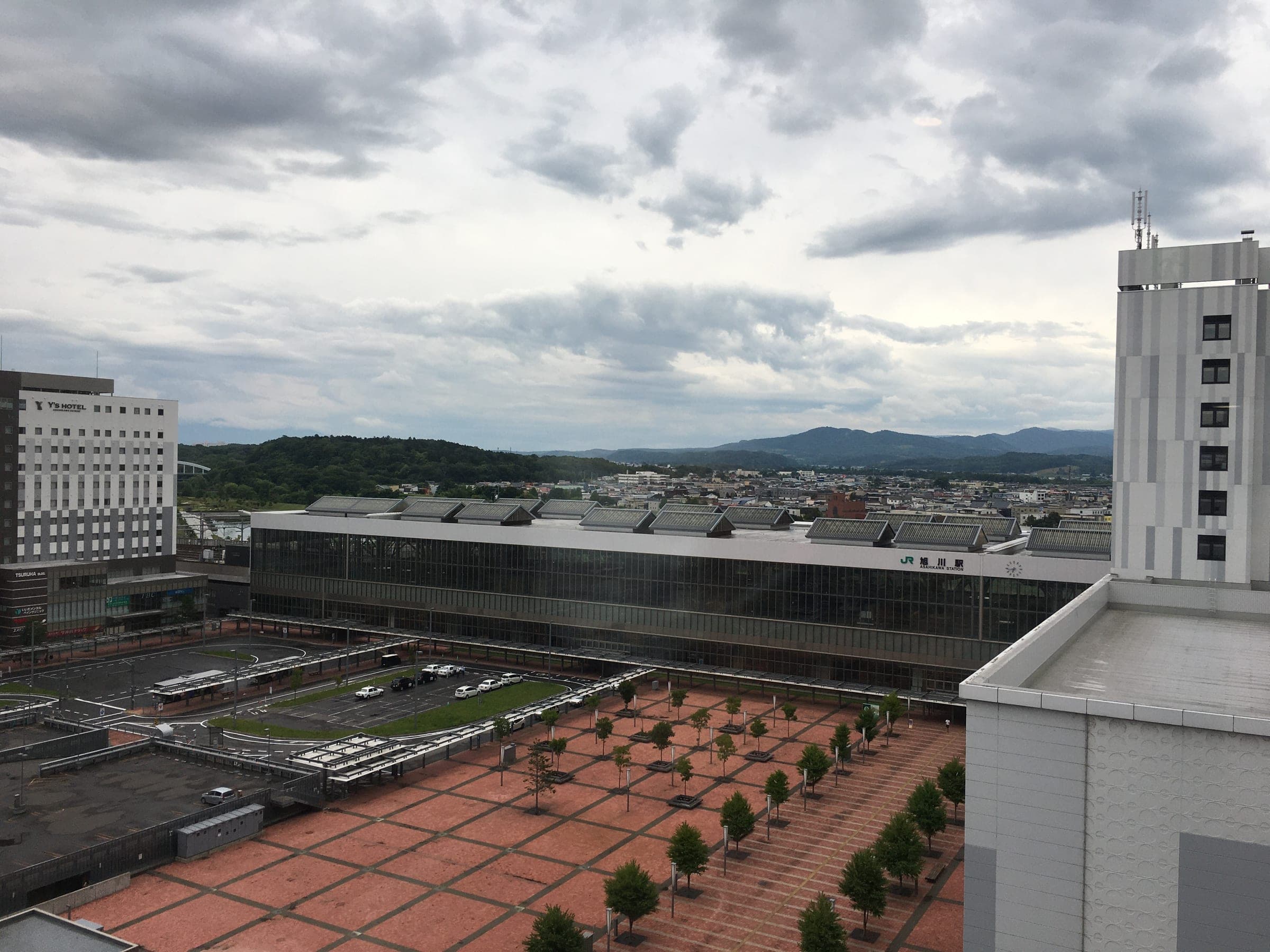 The city stretches beyond Asahikawa Station on a summer morning