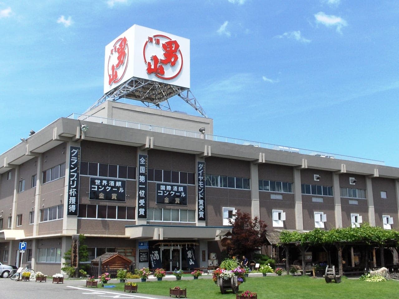 The Otokoyama brewery building in Asahikawa with its red logo sign on the roof