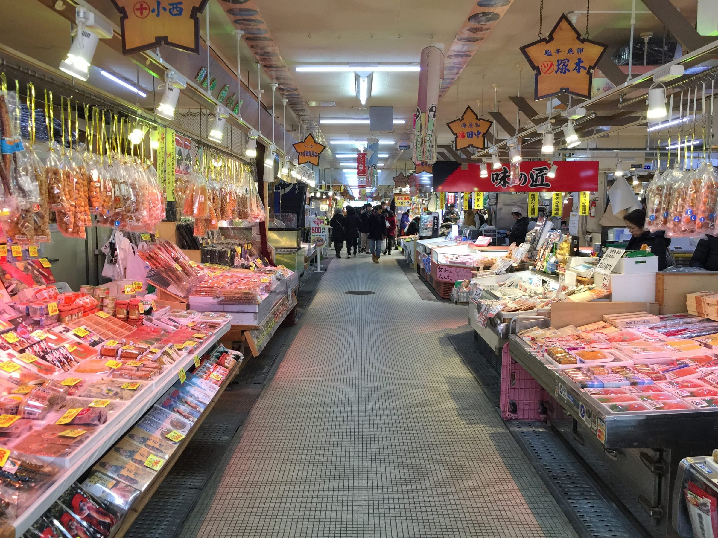 Crab and seafood stalls line a covered aisle in the Hakodate Morning Market