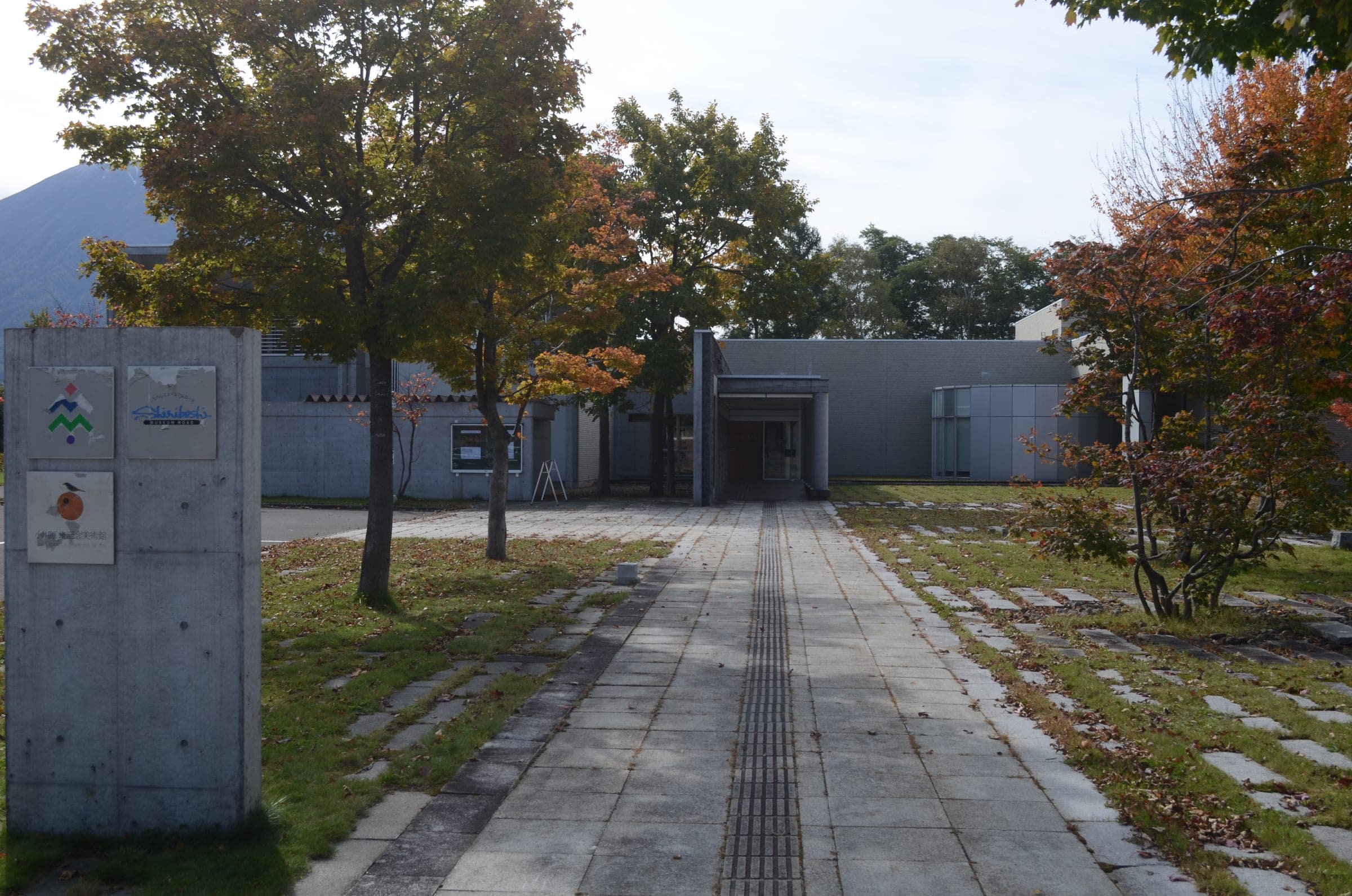 A stone path leads to the low concrete Ogawara Shu Memorial Museum of Art in Kutchan
