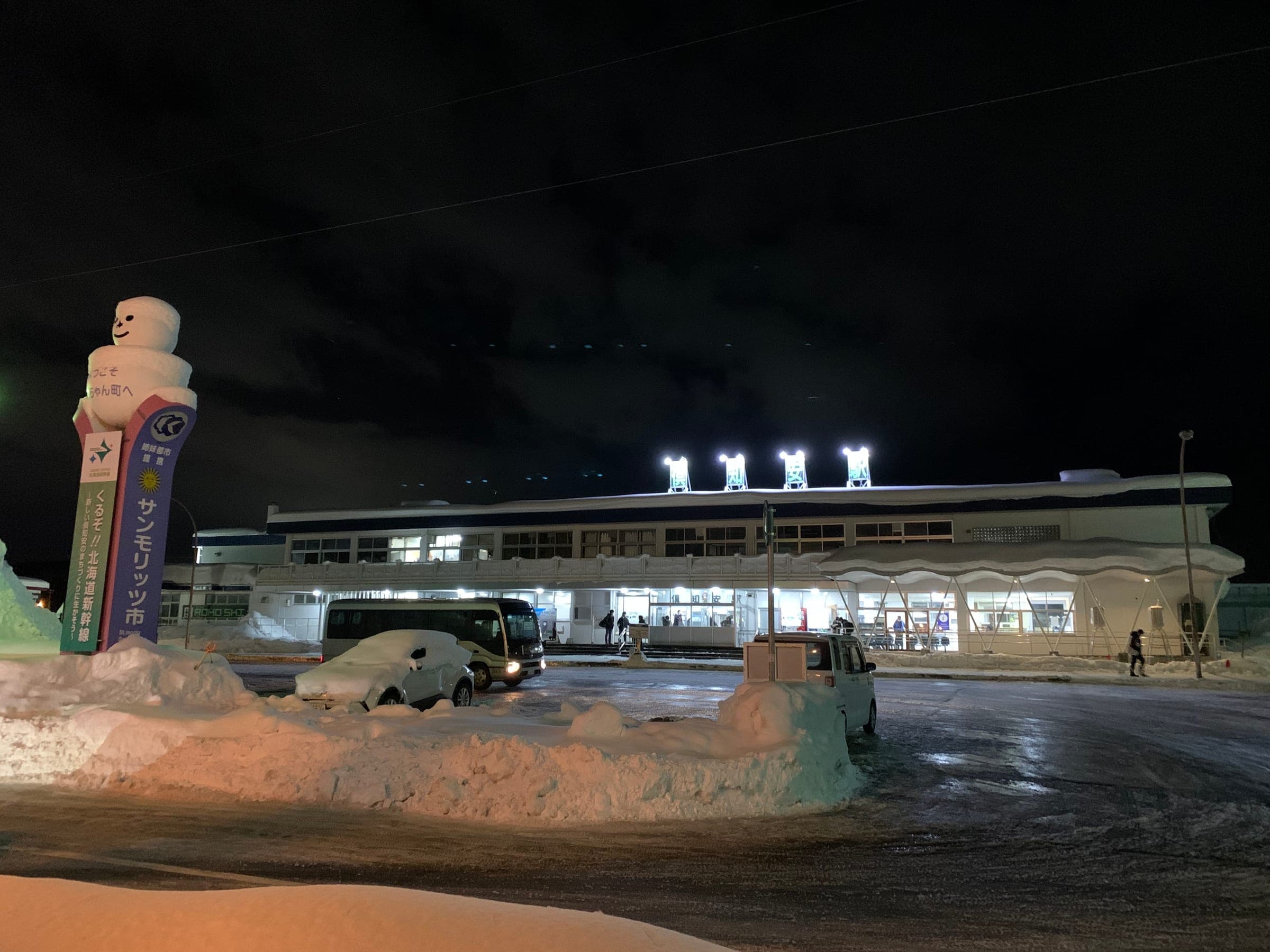 Kutchan Station glows on a snowy New Year's Eve, and Hotel Three M stands a minute's walk away