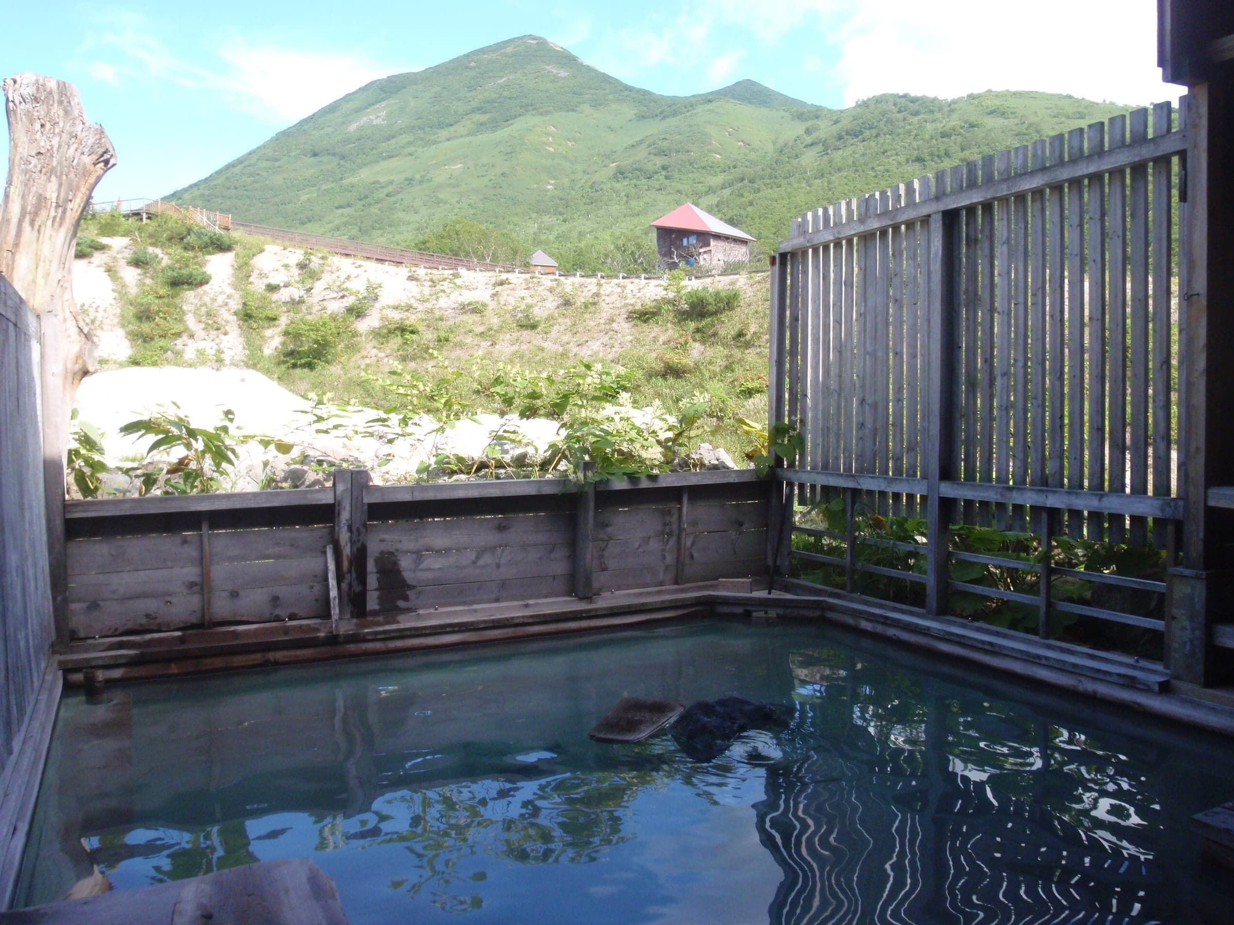 The wooden outdoor bath at Goshiki Onsen looks out at the Niseko range