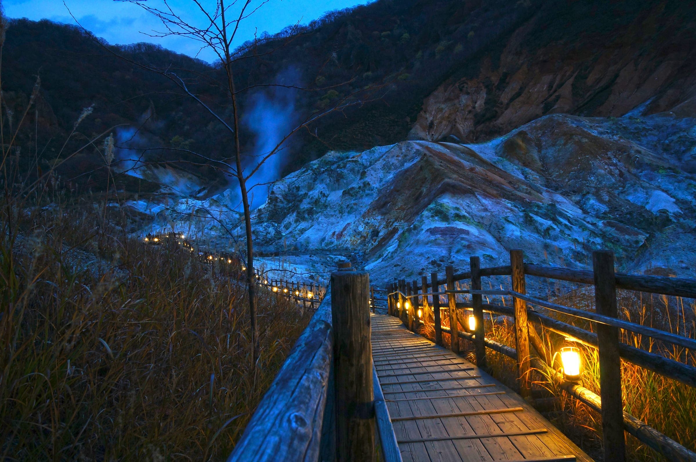 Lanterns light the boardwalk through Jigokudani in Noboribetsu Onsen at dusk