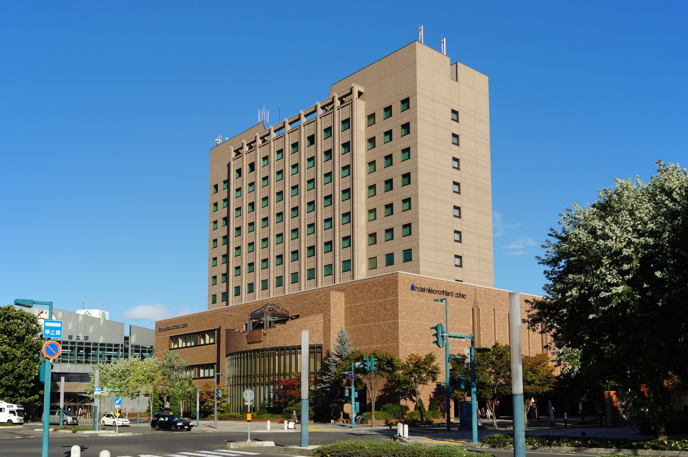 Hotel Nikko Northland Obihiro rises above the trees near the station
