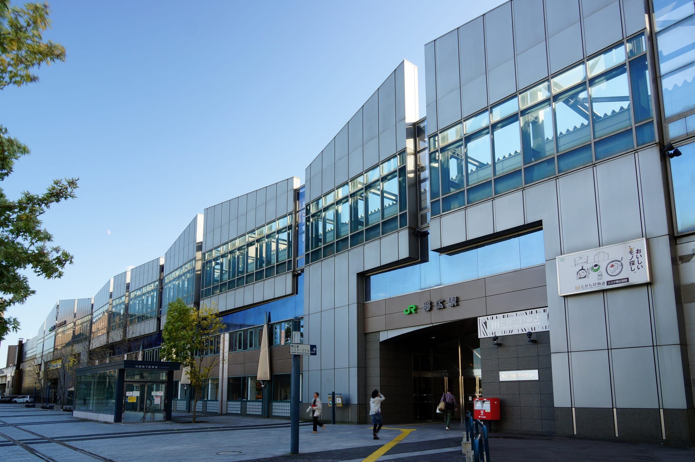 The elevated Obihiro Station building on a clear autumn day