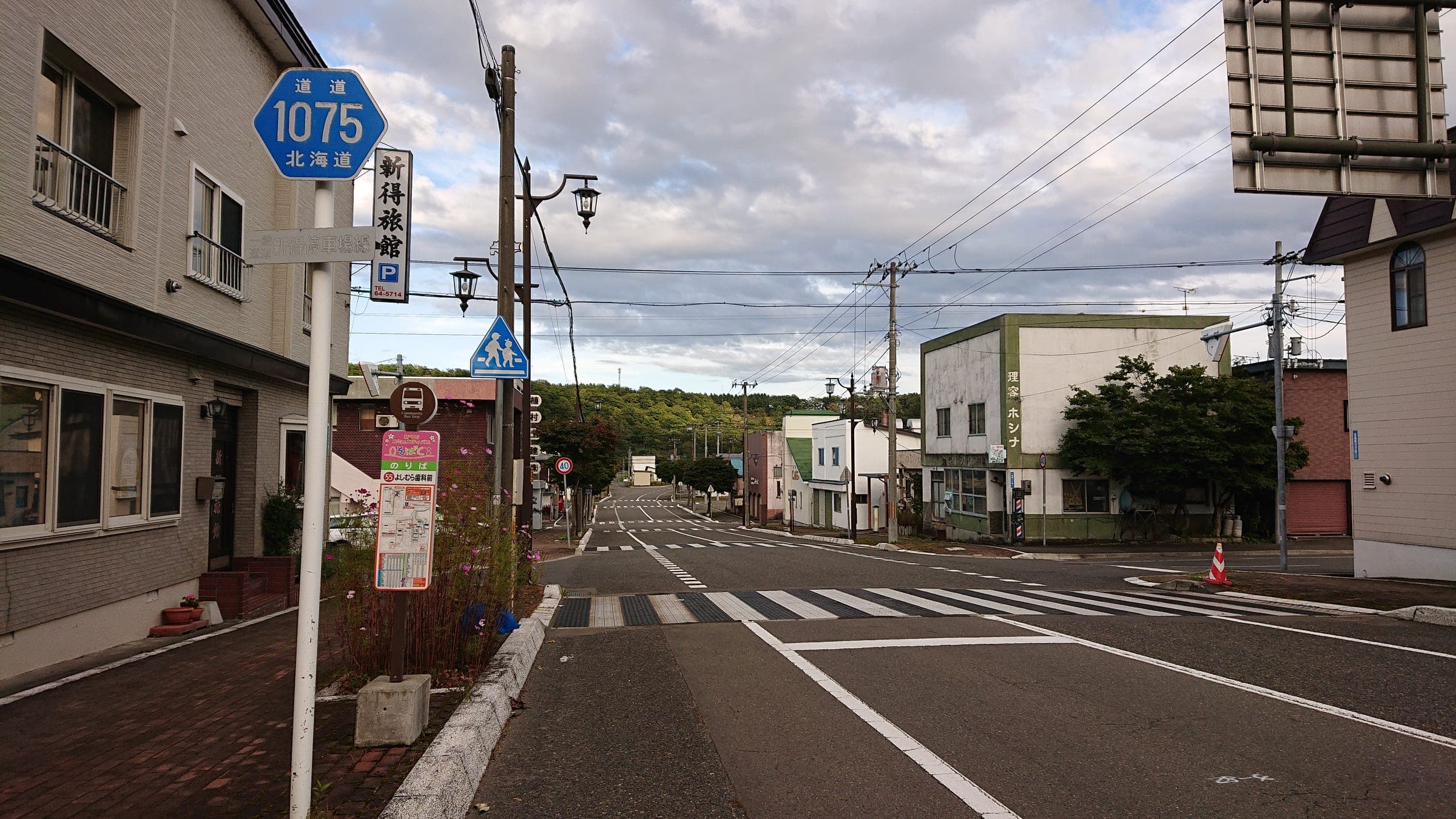 A quiet main street leads away from Shintoku Station toward the hills