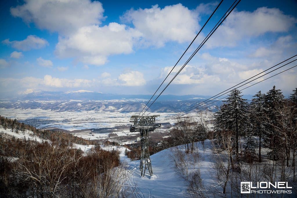 The Furano Ropeway climbs over snowy forest on Furano Nishi-dake with the Furano basin below