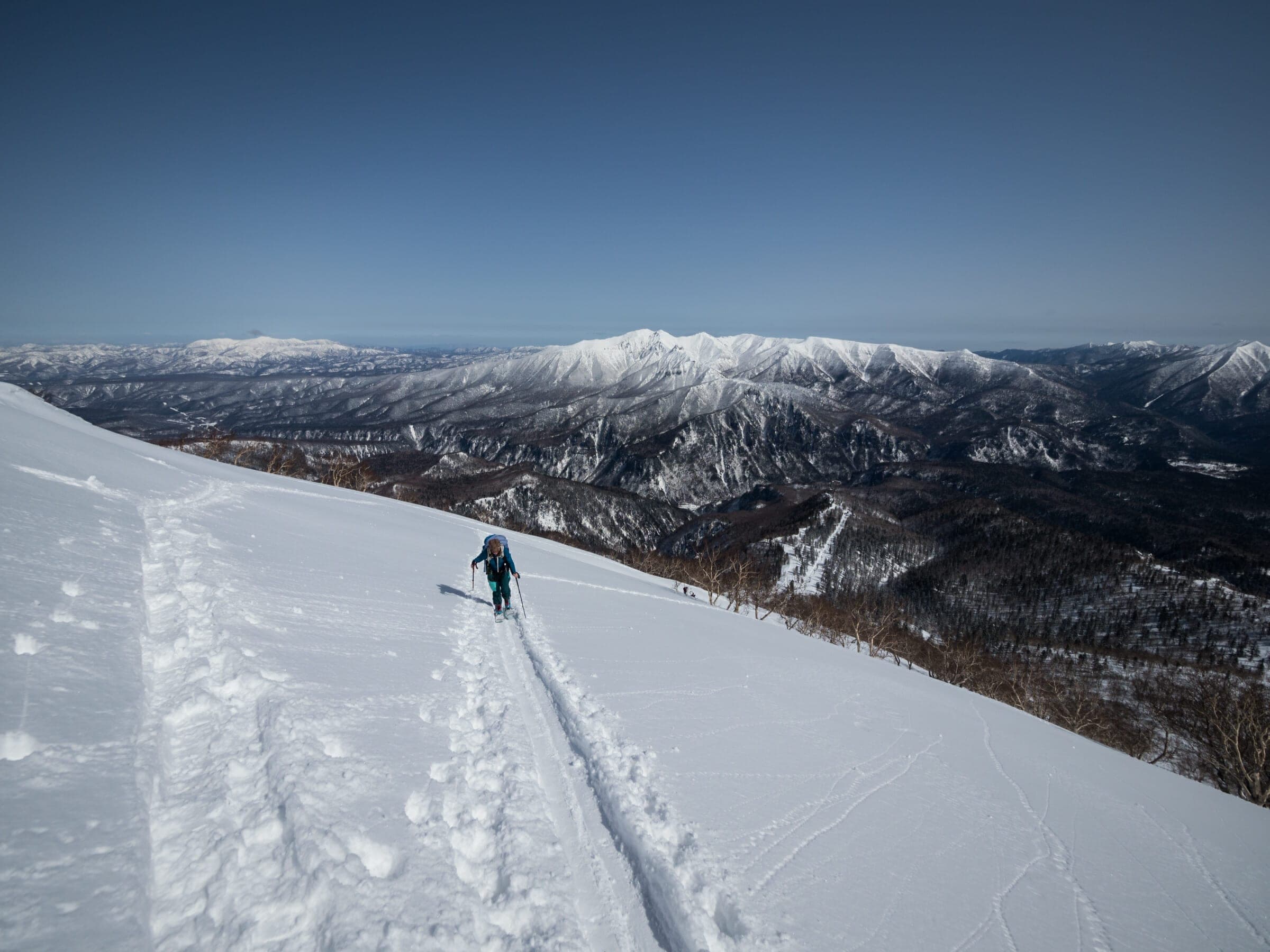 A ski tourer climbs the upper northeast ridge of Kurodake above the Sounkyo valley