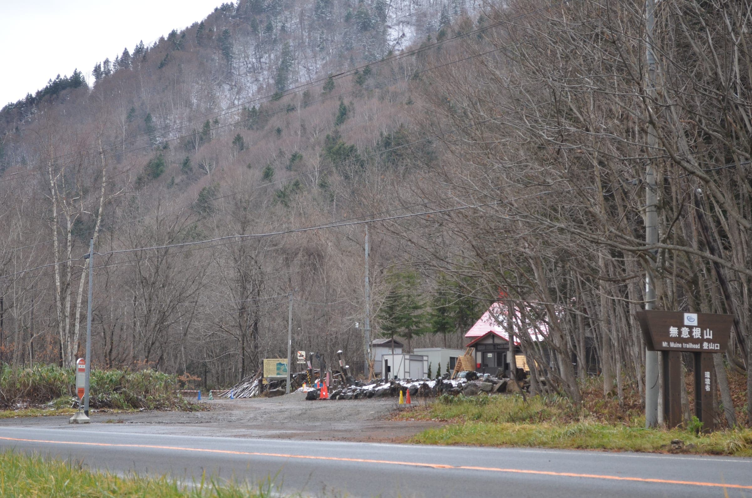 The Usubetsu trailhead for Muine-yama sits beside a forest road below steep wooded slopes in late autumn