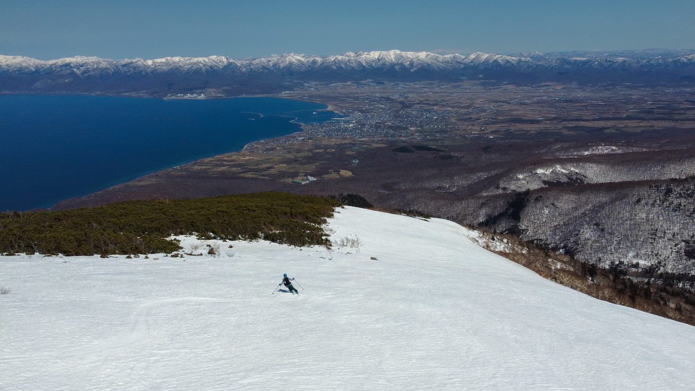 A skier descends the north ridge of Raiden-yama above the Sea of Japan coast