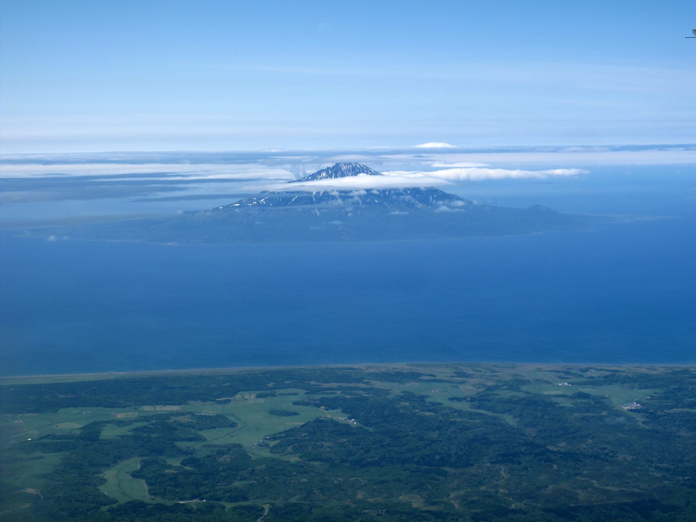 Rishiri-zan rises from the Sea of Japan with snow near its summit in this view from the air
